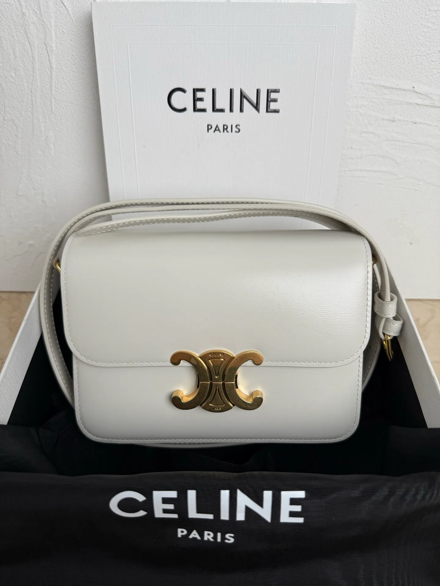 p1560. TEEN TRIOMPHE calfskin handbag This small TRIOMPHE handbag in satin calfskin comes with an adjustable leather shoulder strap and TRIOMPHE exclusive buckle TRIOMPHE brass lock interior zip pocket and interior flat pocket Adjustable leather shoulder strap Length 17 inches (42 cm) 7 X 6 X 2 inches (18.5 X 14 X 6 cm) No.: 188423