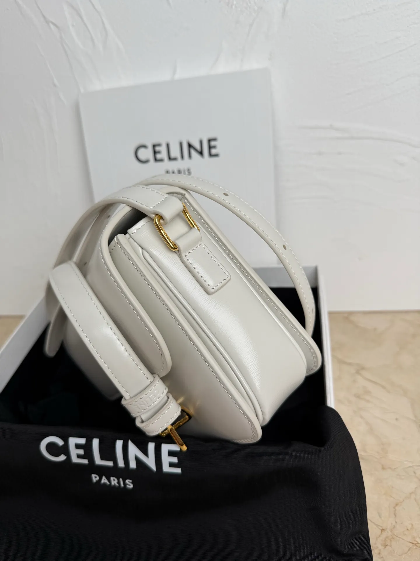 p1560. TEEN TRIOMPHE calfskin handbag This small TRIOMPHE handbag in satin calfskin comes with an adjustable leather shoulder strap and TRIOMPHE exclusive buckle TRIOMPHE brass lock interior zip pocket and interior flat pocket Adjustable leather shoulder strap Length 17 inches (42 cm) 7 X 6 X 2 inches (18.5 X 14 X 6 cm) No.: 188423