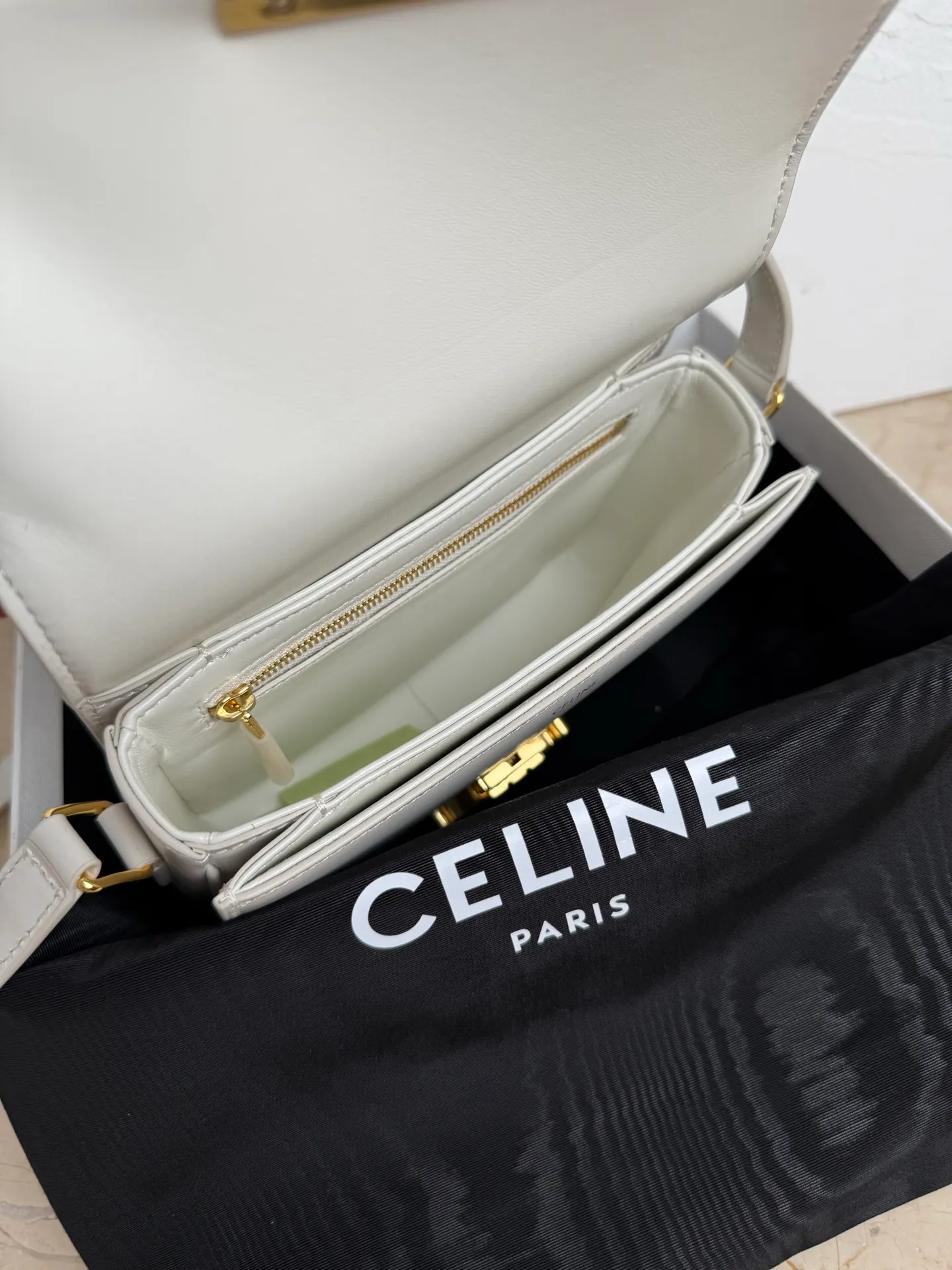 p1560. TEEN TRIOMPHE calfskin handbag This small TRIOMPHE handbag in satin calfskin comes with an adjustable leather shoulder strap and TRIOMPHE exclusive buckle TRIOMPHE brass lock interior zip pocket and interior flat pocket Adjustable leather shoulder strap Length 17 inches (42 cm) 7 X 6 X 2 inches (18.5 X 14 X 6 cm) No.: 188423