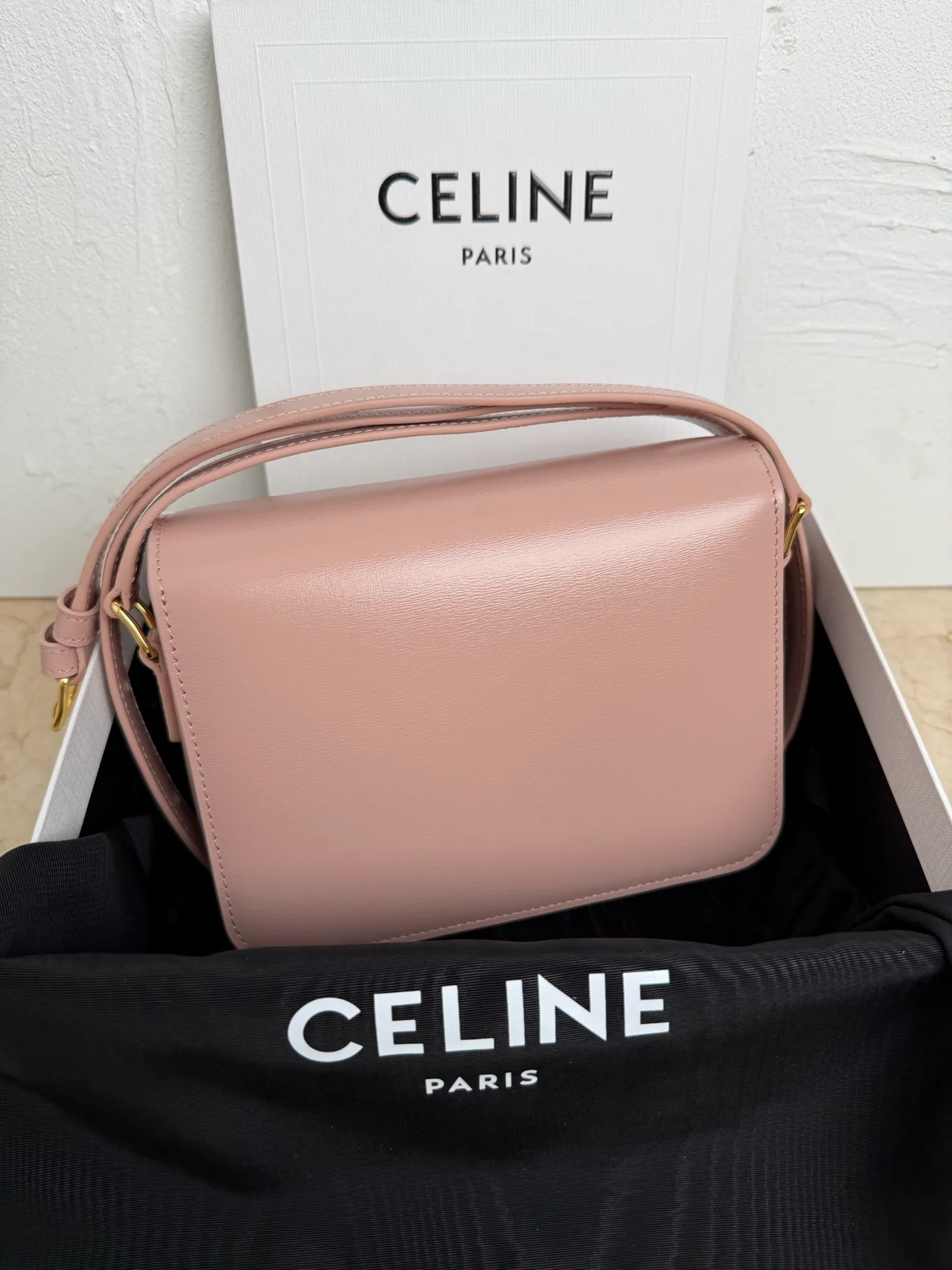 p1560. TEEN TRIOMPHE calfskin handbag This small TRIOMPHE handbag in satin calfskin comes with an adjustable leather shoulder strap and TRIOMPHE exclusive buckle TRIOMPHE brass lock interior zip pocket and interior flat pocket Adjustable leather shoulder strap Length 17 inches (42 cm) 7 X 6 X 2 inches (18.5 X 14 X 6 cm) No.: 188423