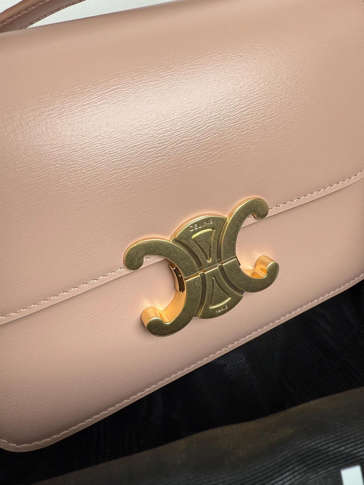 p1560. TEEN TRIOMPHE calfskin handbag This small TRIOMPHE handbag in satin calfskin comes with an adjustable leather shoulder strap and TRIOMPHE exclusive buckle TRIOMPHE brass lock interior zip pocket and interior flat pocket Adjustable leather shoulder strap Length 17 inches (42 cm) 7 X 6 X 2 inches (18.5 X 14 X 6 cm) No.: 188423