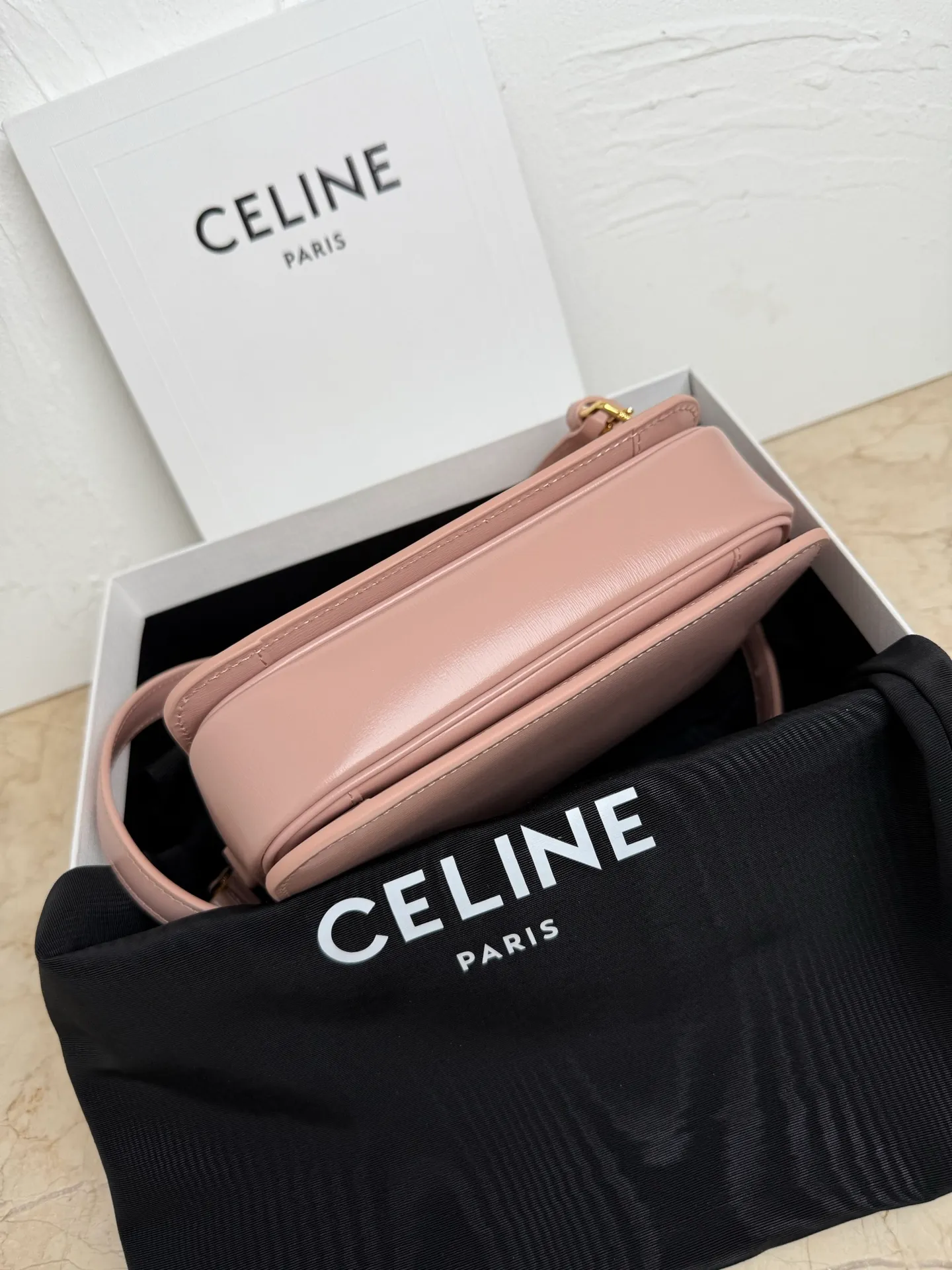 p1560. TEEN TRIOMPHE calfskin handbag This small TRIOMPHE handbag in satin calfskin comes with an adjustable leather shoulder strap and TRIOMPHE exclusive buckle TRIOMPHE brass lock interior zip pocket and interior flat pocket Adjustable leather shoulder strap Length 17 inches (42 cm) 7 X 6 X 2 inches (18.5 X 14 X 6 cm) No.: 188423