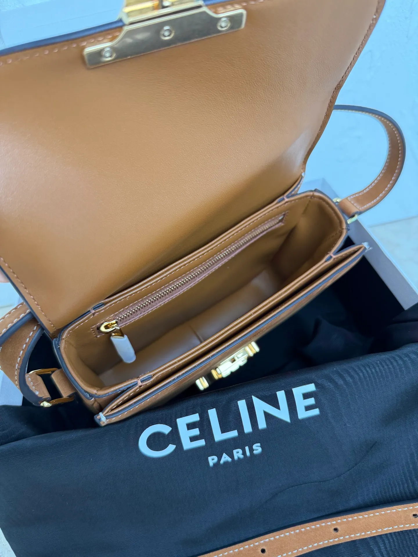 p1560. TEEN TRIOMPHE calfskin handbag This small TRIOMPHE handbag in satin calfskin comes with an adjustable leather shoulder strap and TRIOMPHE exclusive buckle TRIOMPHE brass lock interior zip pocket and interior flat pocket Adjustable leather shoulder strap Length 17 inches (42 cm) 7 X 6 X 2 inches (18.5 X 14 X 6 cm) No.: 188423