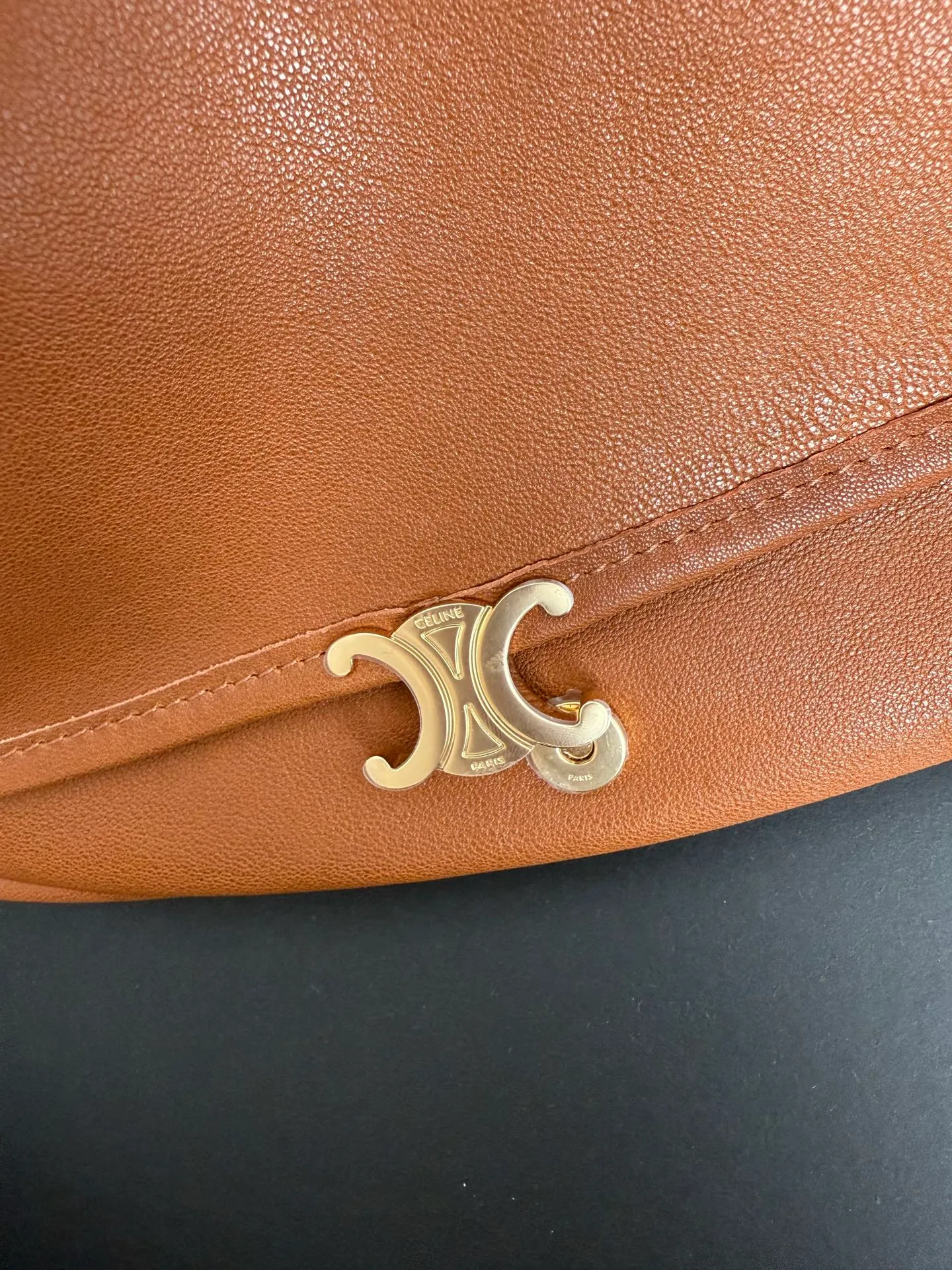 900. Soft Triomphe Halfmoon bag is fashionable✨ CELINE 26SPRING half-moon bag~ Fashionable and special-shaped bag. Large capacity can be used under armpit & one shoulder [kiss an R] I like the shiny leather. The material is shiny lambskin. It is quite light and has a minimalist and neat silhouette. It is fashionable in autumn and winter and can be pinched by the handle✨ Size: 46×19×10 Model: 124142