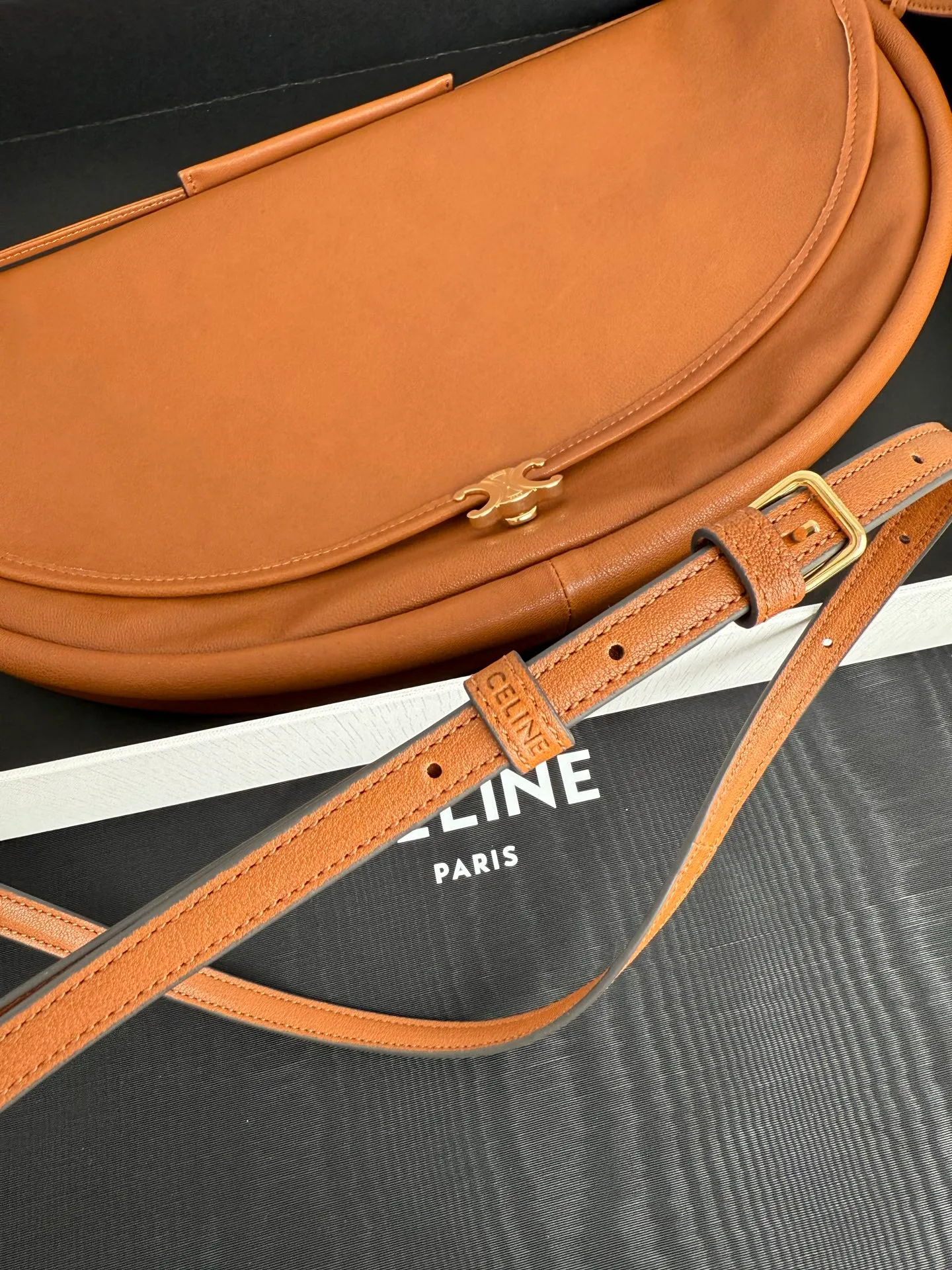 900. Soft Triomphe Halfmoon bag is fashionable✨ CELINE 26SPRING half-moon bag~ Fashionable and special-shaped bag. Large capacity can be used under armpit & one shoulder [kiss an R] I like the shiny leather. The material is shiny lambskin. It is quite light and has a minimalist and neat silhouette. It is fashionable in autumn and winter and can be pinched by the handle✨ Size: 46×19×10 Model: 124142