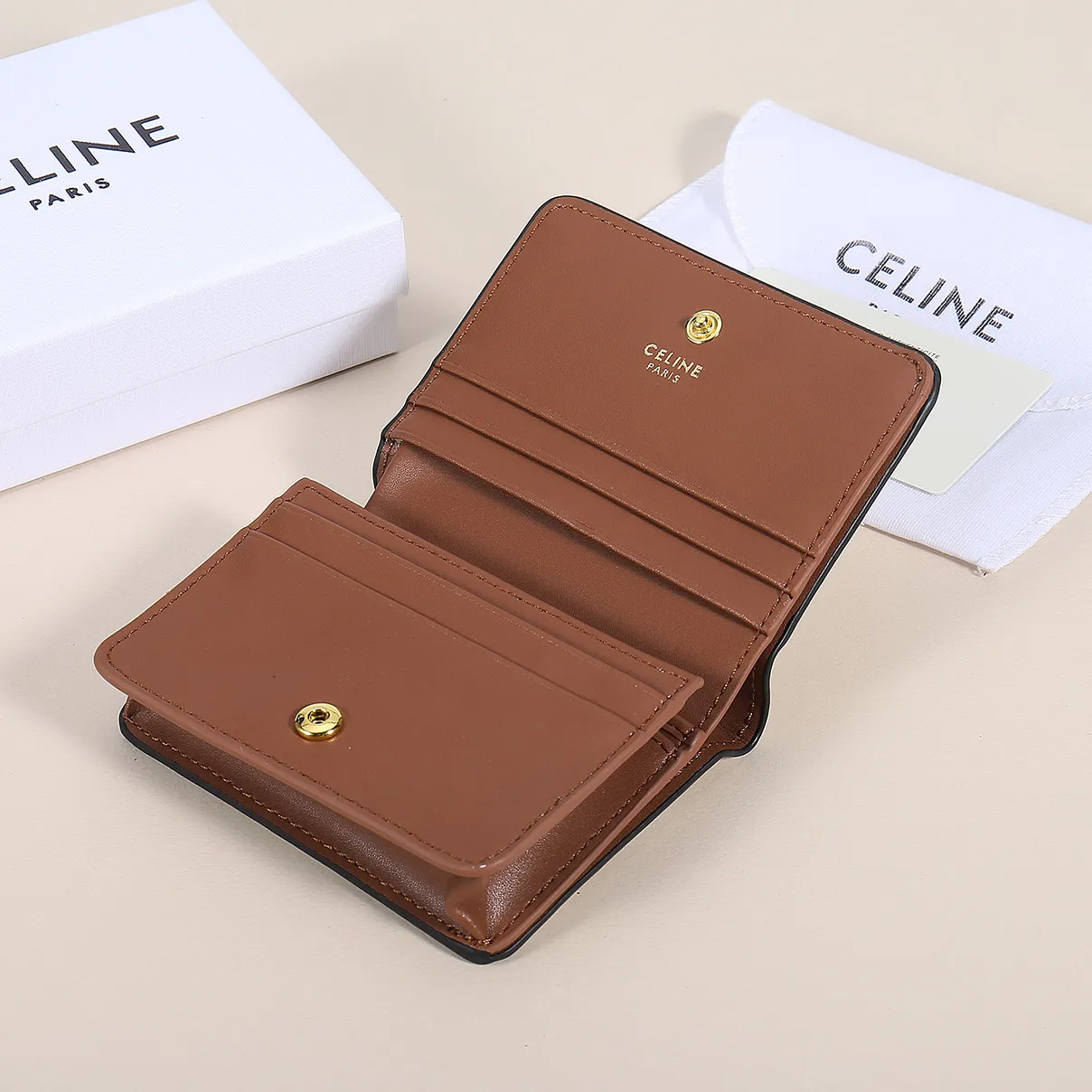 60. Celine classic card holder, TRIOMPHE business card holder, large cowhide interior with plain microfiber TRIOMPHE CANVAS logo print, gold finish TRIOMPHE metal snap closure, 1 zipper coin pocket, 5 card slots, 1 banknote pocket, 1 flat pocket No.: 10K623 Size: 11 X 9 X 3 cm