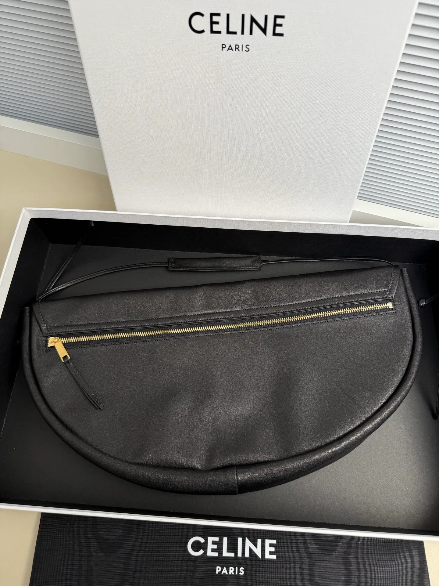 p1800. Soft Triomphe Halfmoon bag is fashionable✨ CELINE 26SPRING half-moon bag~ Fashionable and special-shaped bag. Large capacity can be used under armpit & one shoulder [kiss an R] I like the shiny leather. The material is shiny lambskin. It is quite light and has a minimalist and neat silhouette. It is fashionable in autumn and winter and can be pinched by the handle✨ Size: 46×19×10 Model: 124142