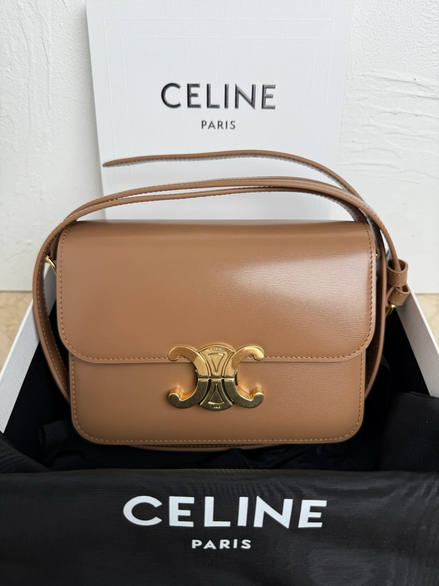 p1560. TEEN TRIOMPHE calfskin handbag This small TRIOMPHE handbag in satin calfskin comes with an adjustable leather shoulder strap and TRIOMPHE exclusive buckle TRIOMPHE brass lock interior zip pocket and interior flat pocket Adjustable leather shoulder strap Length 17 inches (42 cm) 7 X 6 X 2 inches (18.5 X 14 X 6 cm) No.: 188423