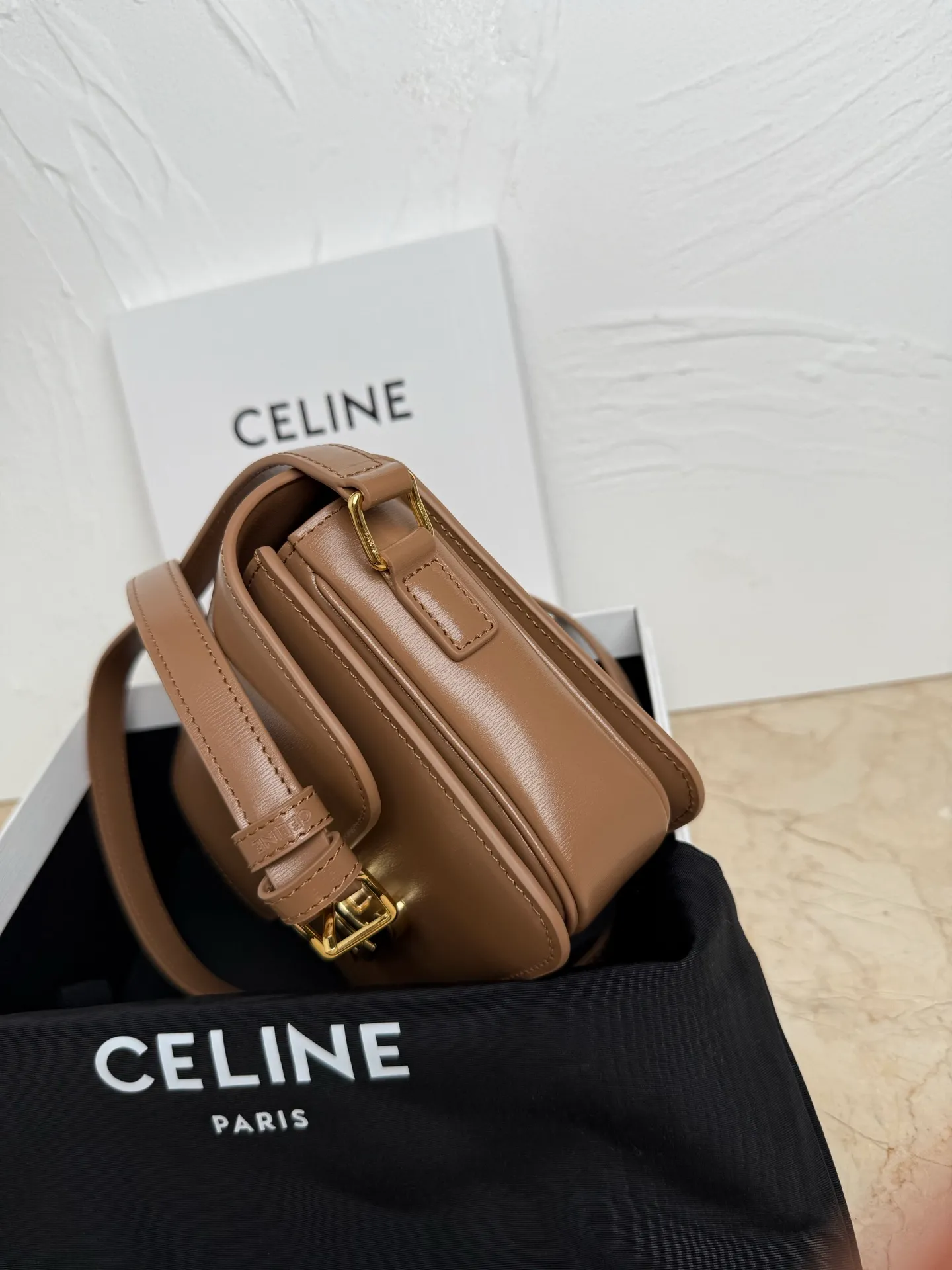 p1560. TEEN TRIOMPHE calfskin handbag This small TRIOMPHE handbag in satin calfskin comes with an adjustable leather shoulder strap and TRIOMPHE exclusive buckle TRIOMPHE brass lock interior zip pocket and interior flat pocket Adjustable leather shoulder strap Length 17 inches (42 cm) 7 X 6 X 2 inches (18.5 X 14 X 6 cm) No.: 188423