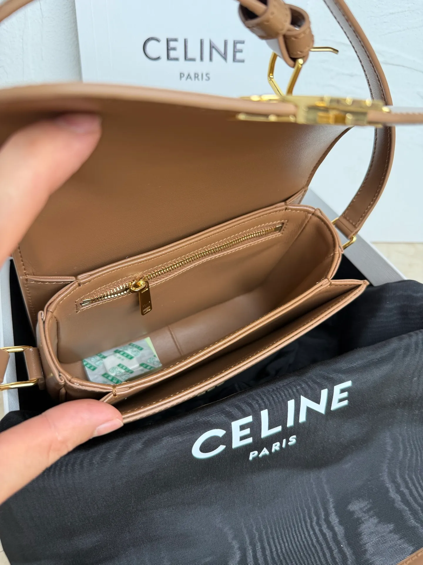 p1560. TEEN TRIOMPHE calfskin handbag This small TRIOMPHE handbag in satin calfskin comes with an adjustable leather shoulder strap and TRIOMPHE exclusive buckle TRIOMPHE brass lock interior zip pocket and interior flat pocket Adjustable leather shoulder strap Length 17 inches (42 cm) 7 X 6 X 2 inches (18.5 X 14 X 6 cm) No.: 188423