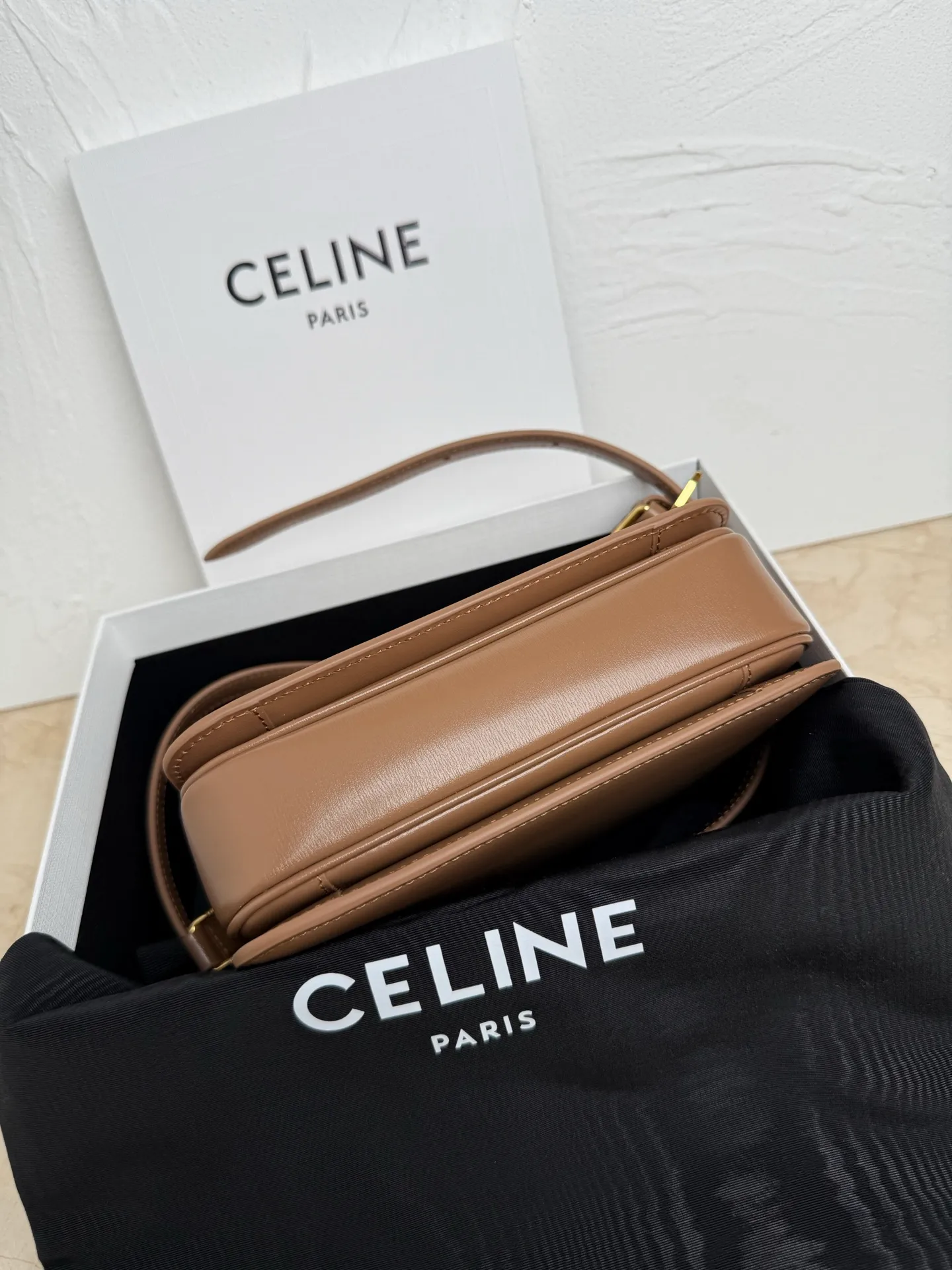 p1560. TEEN TRIOMPHE calfskin handbag This small TRIOMPHE handbag in satin calfskin comes with an adjustable leather shoulder strap and TRIOMPHE exclusive buckle TRIOMPHE brass lock interior zip pocket and interior flat pocket Adjustable leather shoulder strap Length 17 inches (42 cm) 7 X 6 X 2 inches (18.5 X 14 X 6 cm) No.: 188423