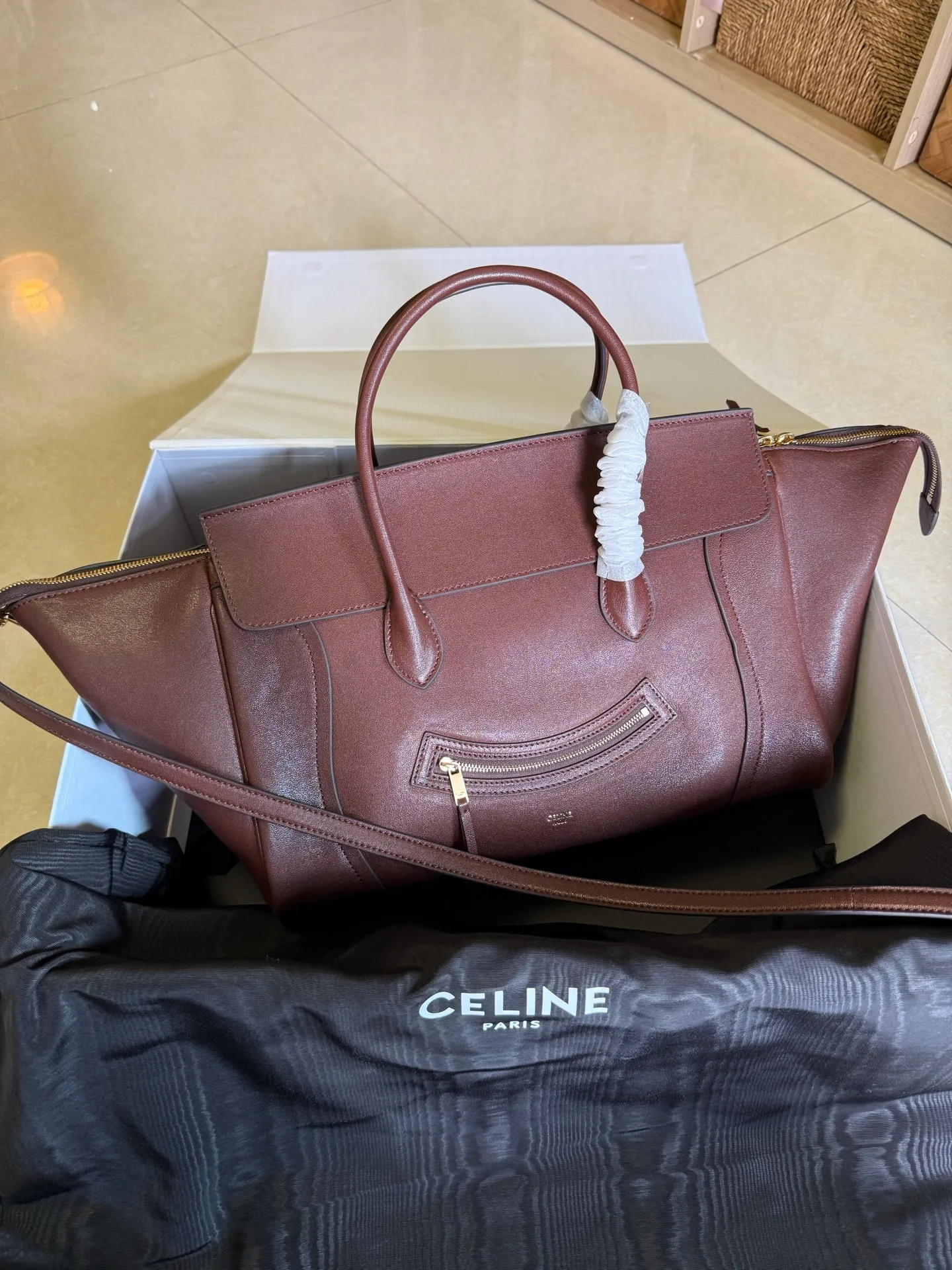 p2300 new products are online 🅰️🅰️ 26 spring series new smiley bag 👛 😐change🙂, CE smiley bag is back with a new look! CE PRINTEMPS 2026 Spring Series! NEW LUGGAGE The new version of the smiley bag, the classic in memory, is now available again! 👜Lightweight material and modern lines are still the most recognizable It Bag! Showing a simple and neat modern temperament. The new creative director Michael Rider made a surprise return of the "Smiley Face Bag" at his 2026 spring debut. The smooth, delicate and lustrous leather, backstitching technology and piping design create a soft and round horizontal outline. The side zipper design presents a unique smile arc, cleverly echoing the name of the "Smiley Face Bag". The classic design is reinterpreted through modern silhouettes, making the overall design more lightweight and versatile, presenting an elegant yet casual style! Style No.: 123693 Color: Dark Brown Size: Bottom 36x22x16cm Bag opening 56cm