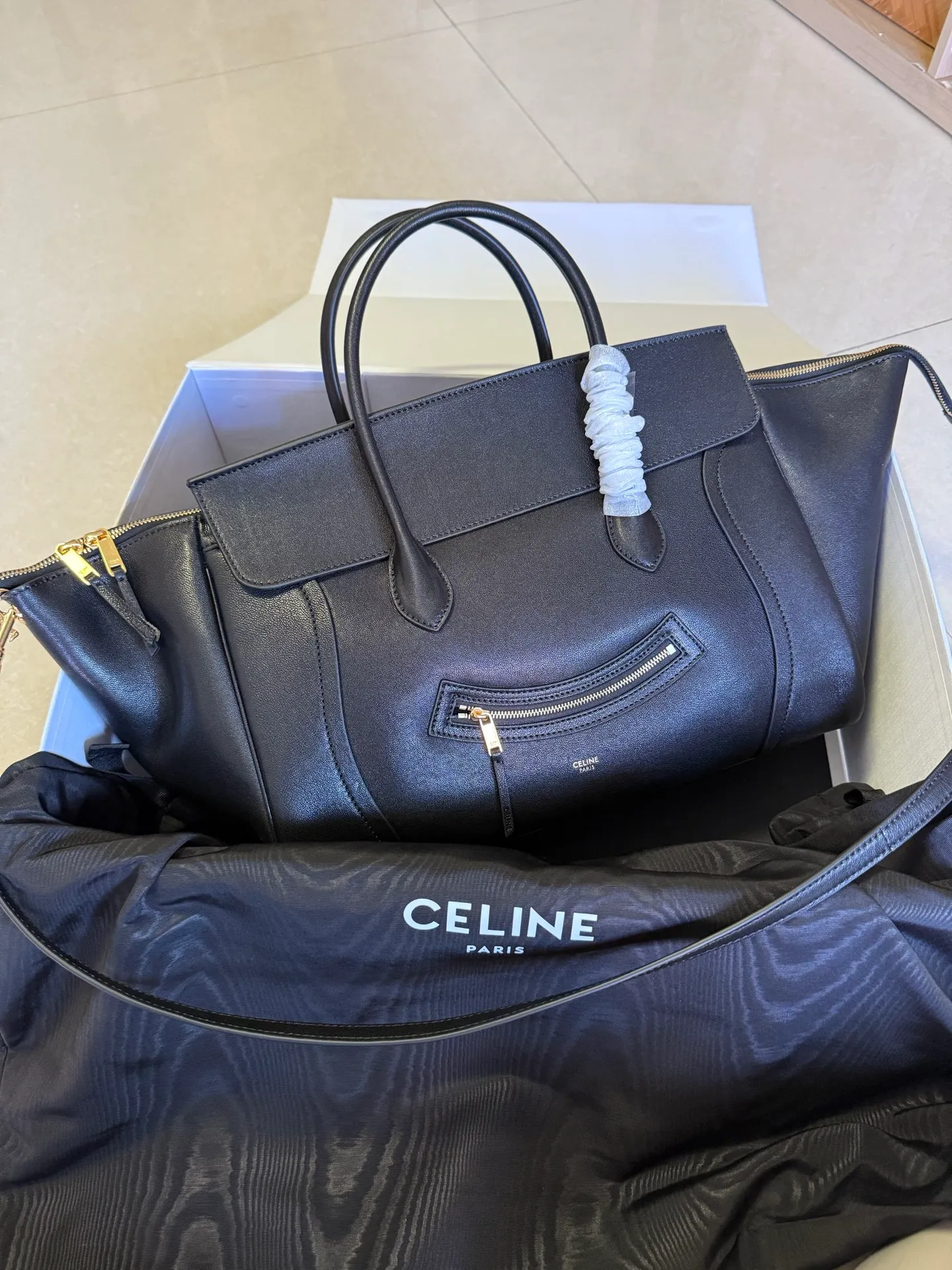 p2300 new products are online 🅰️🅰️ 26 spring series new smiley bag 👛 😐change🙂, CE smiley bag is back with a new look! CE PRINTEMPS 2026 Spring Series! NEW LUGGAGE The new version of the smiley bag, the classic in memory, is now available again! 👜Lightweight material and modern lines are still the most recognizable It Bag! Showing a simple and neat modern temperament. The new creative director Michael Rider made a surprise return of the "Smiley Face Bag" at his 2026 spring debut. The smooth, delicate and lustrous leather, backstitching technology and piping design create a soft and round horizontal outline. The side zipper design presents a unique smile arc, cleverly echoing the name of the "Smiley Face Bag". The classic design is reinterpreted through modern silhouettes, making the overall design more lightweight and versatile, presenting an elegant yet casual style! Style No.: 123693 Color: Black Size: Bottom 36x22x16cm Bag opening 56cm