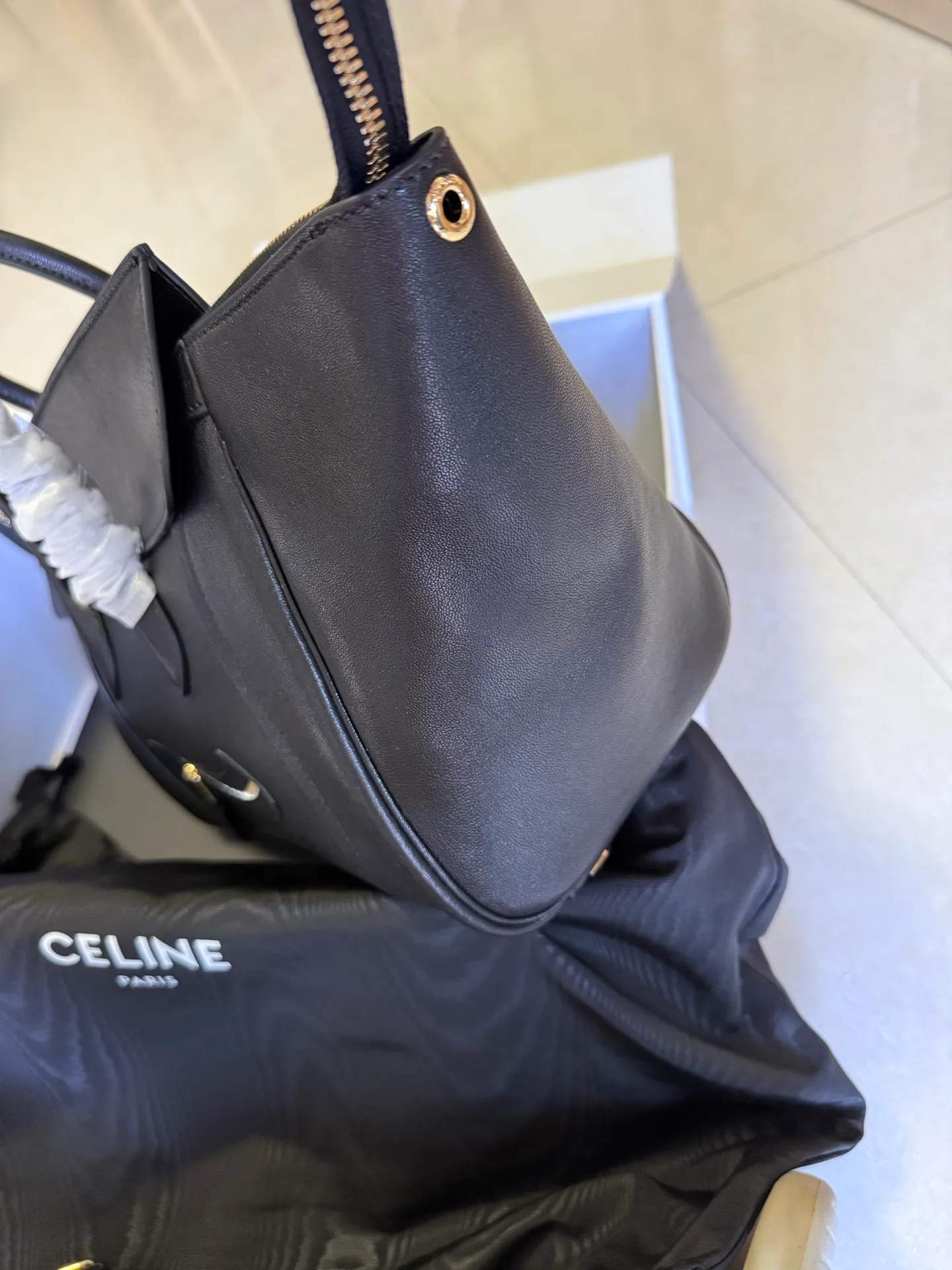 p2300 new products are online 🅰️🅰️ 26 spring series new smiley bag 👛 😐change🙂, CE smiley bag is back with a new look! CE PRINTEMPS 2026 Spring Series! NEW LUGGAGE The new version of the smiley bag, the classic in memory, is now available again! 👜Lightweight material and modern lines are still the most recognizable It Bag! Showing a simple and neat modern temperament. The new creative director Michael Rider made a surprise return of the "Smiley Face Bag" at his 2026 spring debut. The smooth, delicate and lustrous leather, backstitching technology and piping design create a soft and round horizontal outline. The side zipper design presents a unique smile arc, cleverly echoing the name of the "Smiley Face Bag". The classic design is reinterpreted through modern silhouettes, making the overall design more lightweight and versatile, presenting an elegant yet casual style! Style No.: 123693 Color: Black Size: Bottom 36x22x16cm Bag opening 56cm