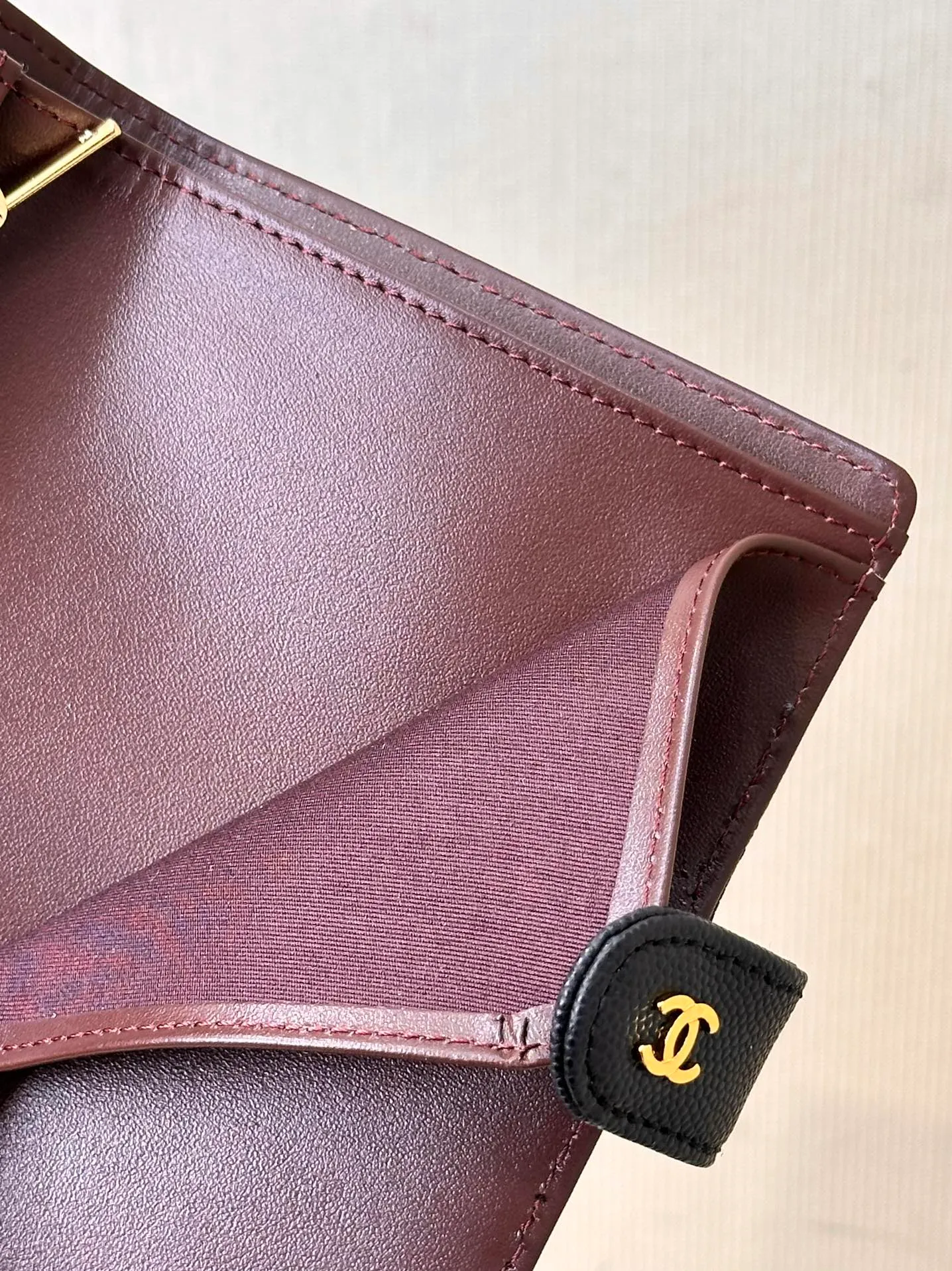 96066 The interior is made of burgundy calfskin. The leather has its own luster, and the texture is clear and delicate. It has various card slots on the side and an anti-counterfeiting code design on the inside.