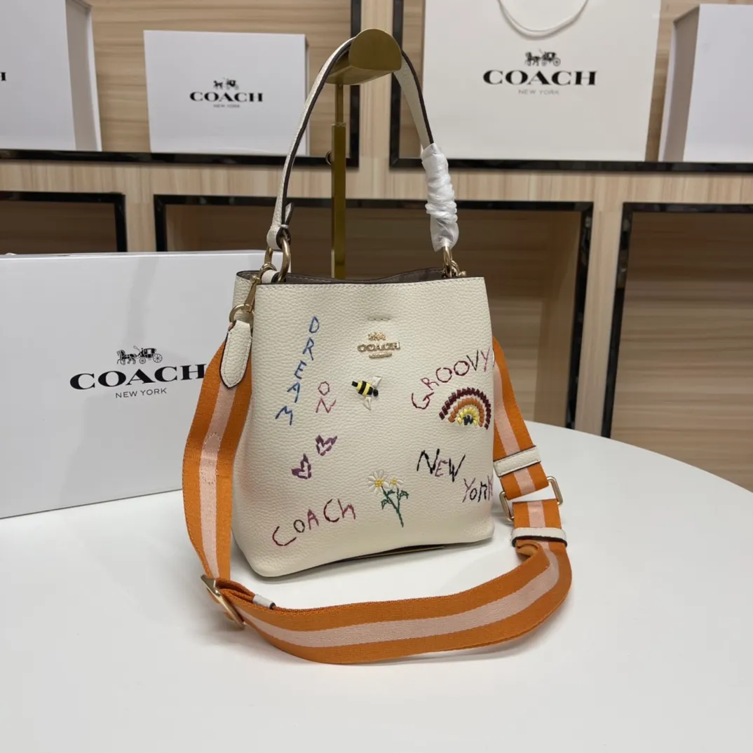 Batch 520💰coach/Coach new model, co-branded with Basquiat, the latest model, small embroidered woven bucket bag. 👑, with cloth shoulder straps and wrist straps, it can meet various travel matching needs. Full leather bag body, with first-layer cowhide 🌹Size 21x22X10.5