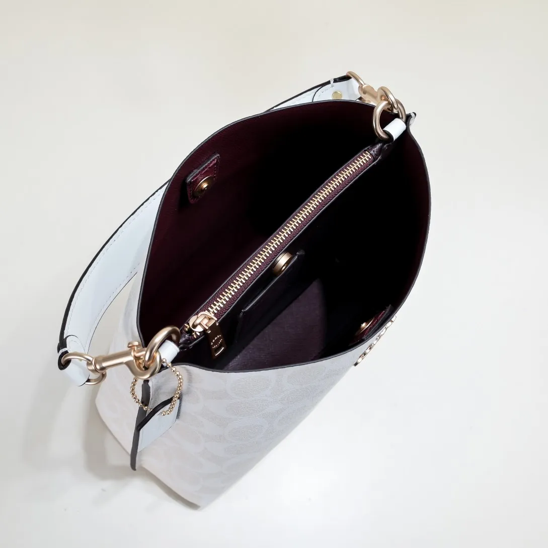 CA582, Coach's latest Mollie series bucket bag, small size, made of old PVC material and cowhide material. It is equipped with two detachable shoulder straps, long and short, which can be carried by hand or cross-body. There is a zipper compartment in the middle of the bag, which has good accommodation. The flat body of the bag is more comfortable on the upper body. Size:22*20*10cm