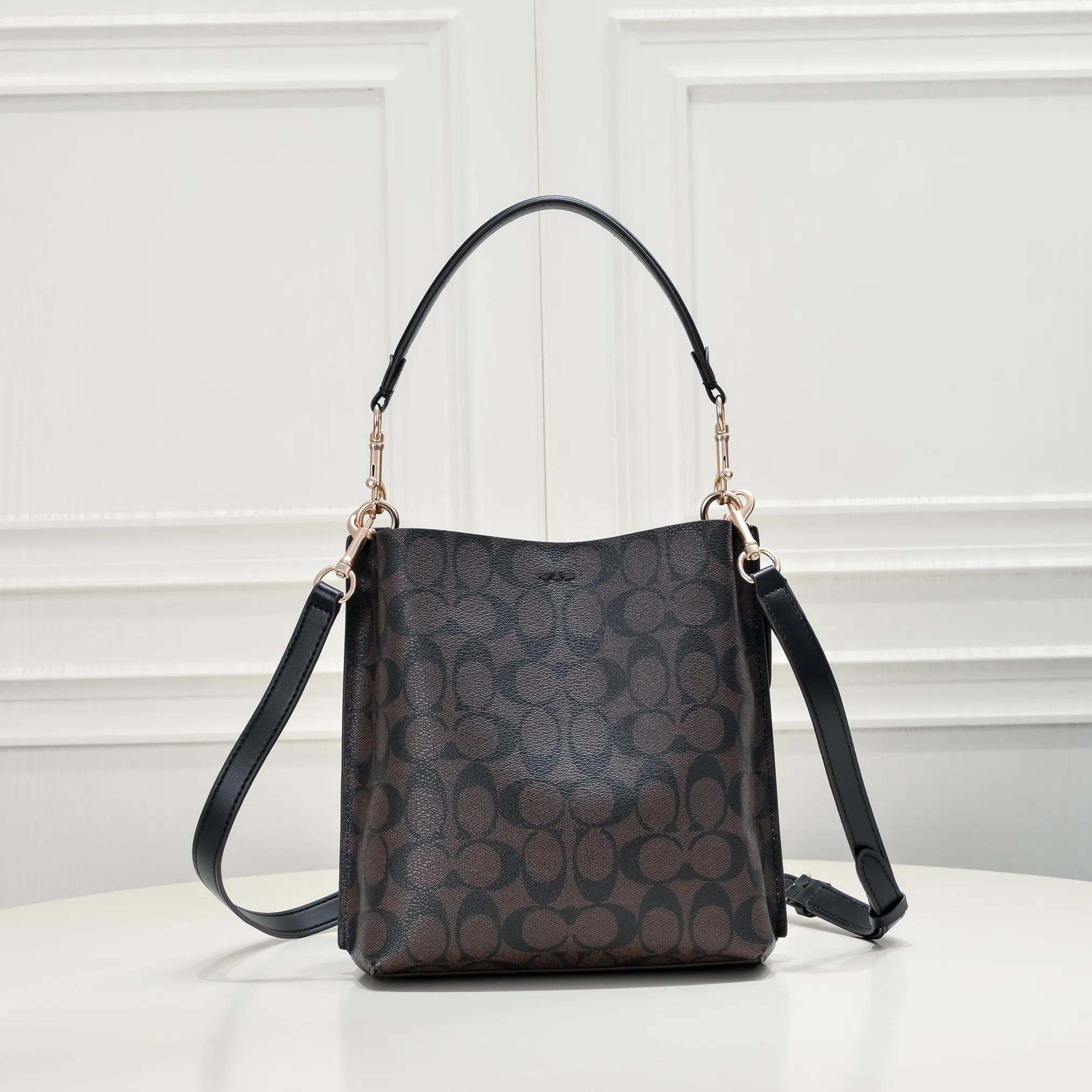 CA582, Coach's latest Mollie series bucket bag, small size, made of old PVC material and cowhide material. It is equipped with two detachable shoulder straps, long and short, which can be carried by hand or cross-body. There is a zipper compartment in the middle of the bag, which has good accommodation. The flat body of the bag is more comfortable on the upper body. Size:22*20*10cm