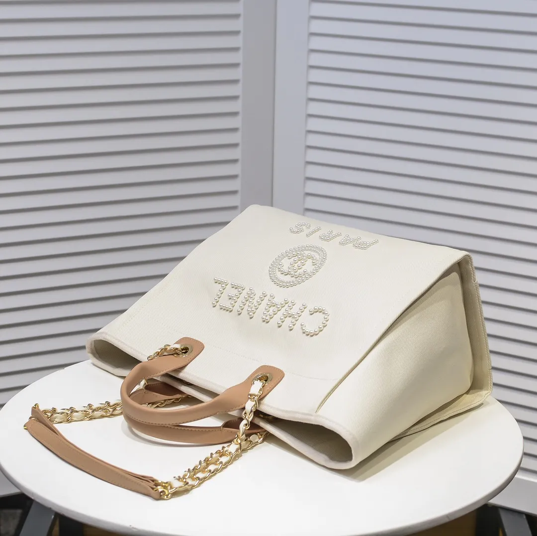 💰380￥4100 The most beautiful holiday style shopping bag in spring and summer. Chanel tote chain canvas beach bag in stock. New stripe😻✨This beach bag shopping bag is made of canvas material. Its simple and casual design is very popular. It is large in capacity and light and fashionable. In addition to being suitable for daily use, it is also more suitable for relaxed and casual wear when traveling. It is extremely practical! 💙 Size: 38*30*21cm / Style number: 66941