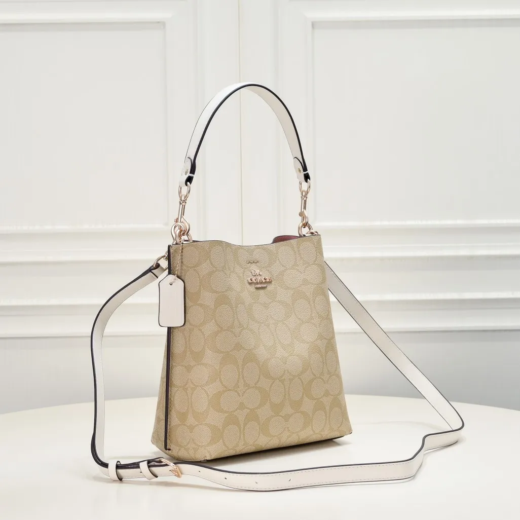 CA582, Coach's latest Mollie series bucket bag, small size, made of old PVC material and cowhide material. It is equipped with two detachable shoulder straps, long and short, which can be carried by hand or cross-body. There is a zipper compartment in the middle of the bag, which has good accommodation. The flat body of the bag is more comfortable on the upper body. Size:22*20*10cm