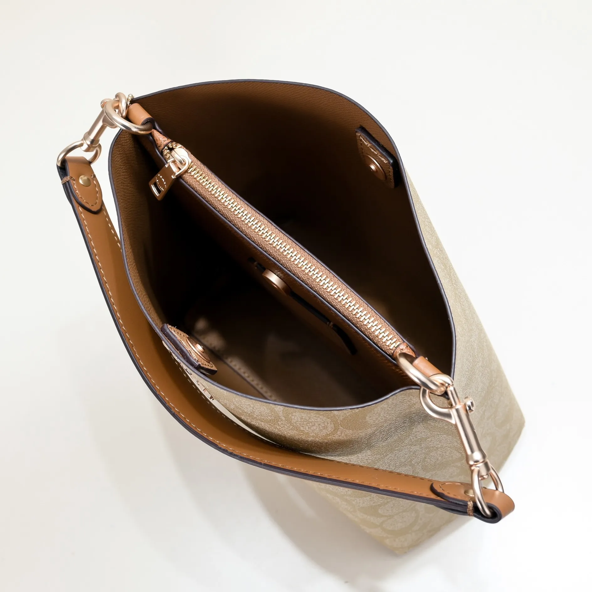 CA582, Coach's latest Mollie series bucket bag, small size, made of old PVC material and cowhide material. It is equipped with two detachable shoulder straps, long and short, which can be carried by hand or cross-body. There is a zipper compartment in the middle of the bag, which has good accommodation. The flat body of the bag is more comfortable on the upper body. Size:22*20*10cm