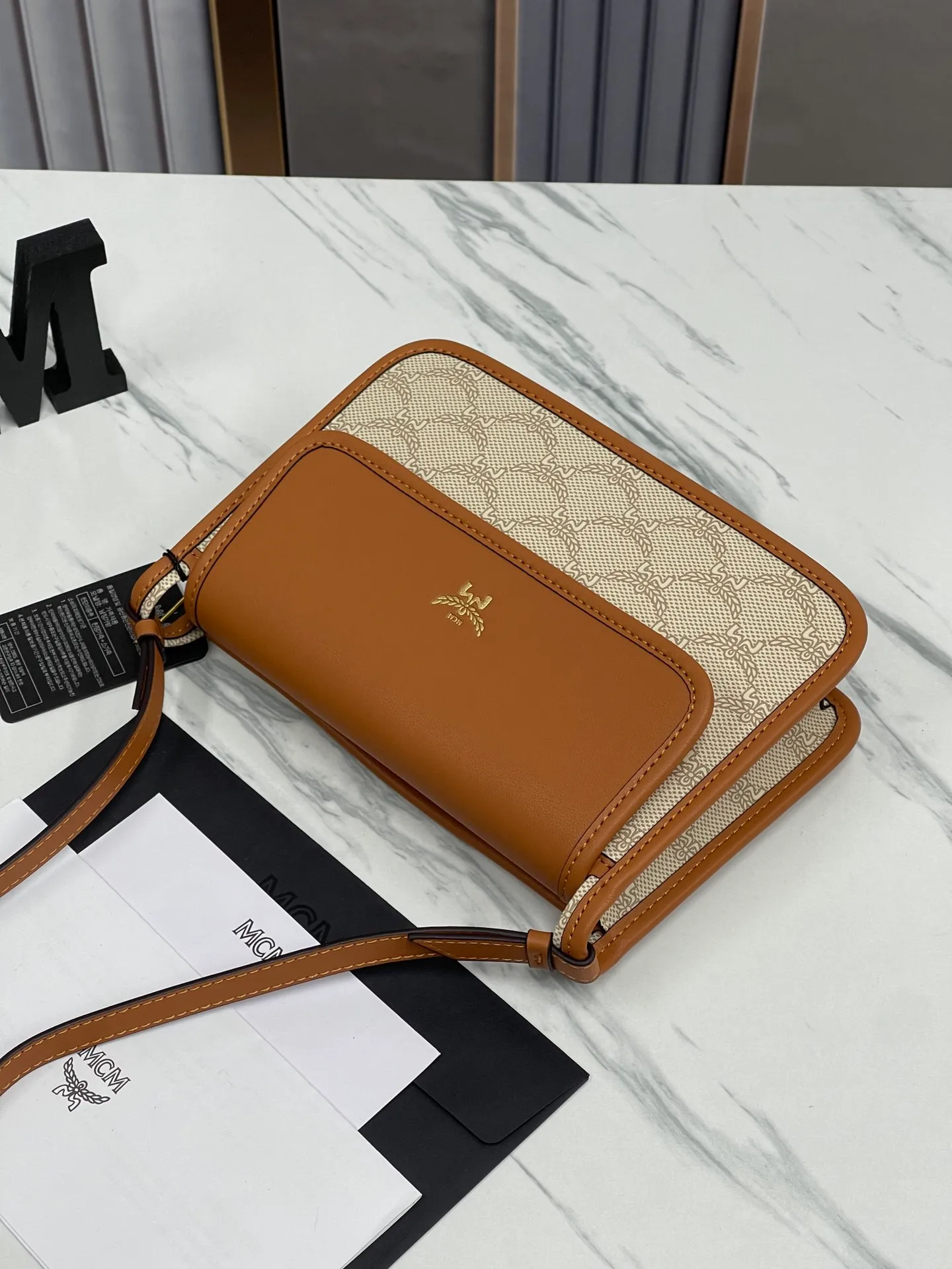 Batch 420💰🌺MCM counter new crossbody bag model 706🔥This crossbody bag is decorated with the classic Lauretos pattern that symbolizes victory. Its modular nature makes it versatile. The bag also comes with a removable flap clutch that attaches to the crossbody bag with a magnetic snap. · Adjustable leather shoulder strap from 100 to 126 cm · Magnetic snap fastening · Removable classic pattern clutch with internal card slot Visetos classic pattern · Gold-tone brass hardware Size 22 · 14 · 6.5