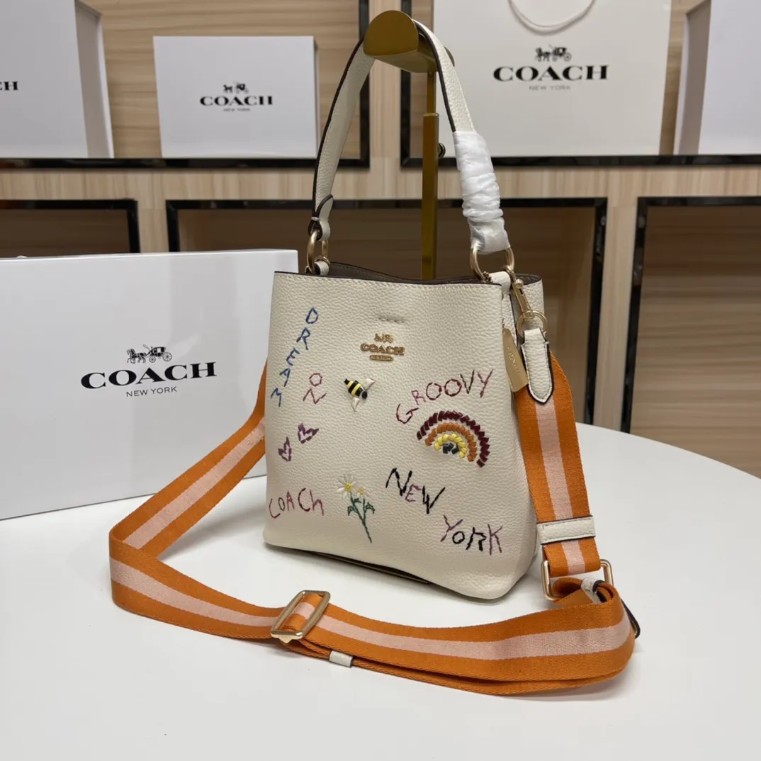 Batch 520💰coach/Coach new model, co-branded with Basquiat, the latest model, small embroidered woven bucket bag. 👑, with cloth shoulder straps and wrist straps, it can meet various travel matching needs. Full leather bag body, with first-layer cowhide 🌹Size 21x22X10.5