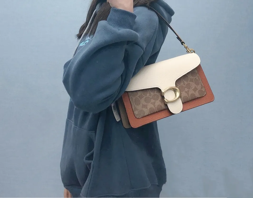 Coach Tabby Bacchus bag 91215 has a new color for spring and summer, with milk tea and orange logo, super gentle color scheme ~ the flap part is made of beige pebbled cowhide, the front is the most classic khaki presbyopic logo, and the sides and long shoulder straps are milk tea color. The two shoulder straps can be replaced at will, and there will always be a style that suits you. It can be carried by hand, carried under the armpit, or carried cross-body. It is a multi-purpose bag and has a super age-friendly and versatile color scheme! Approximate size: 26*15*7.5cm