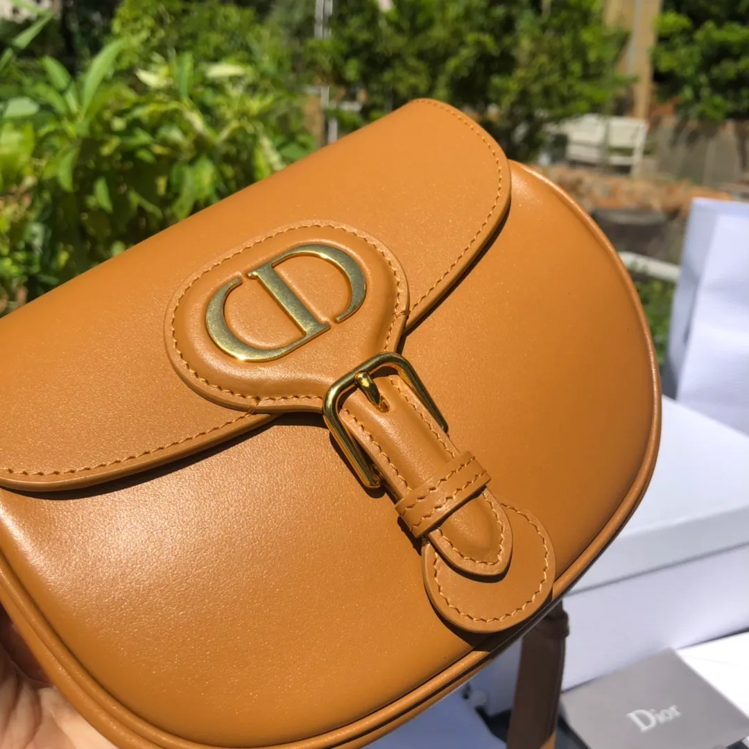 ❗️❗️❗️Free shipping with SF Express for year-end event❗️❗️❗️💰1700 Small size: 18×14×5cm Dior’s new products are available through overseas channels! The Dior Bobby bag is designed as a shoulder bag, highlighting its elegant silhouette and harmonious proportions. This small bag is crafted from camel glossy calfskin and accented with antiqued gold hardware for added style. The interior is designed with suede leather, which is soft and rich in texture. With a detachable and adjustable shoulder strap embellished with a military-style buckle, it can be worn on the shoulder, cross-body or handheld.
