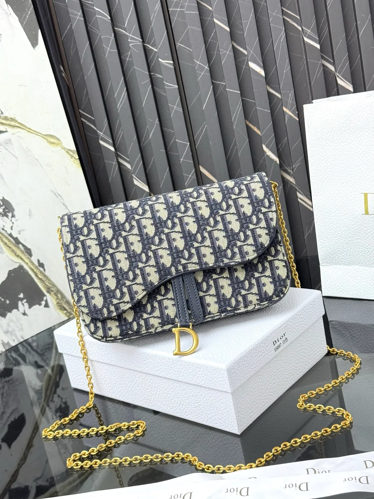 💰290💰 This saddle chain handbag has smooth and coordinated lines, making it a fashionable and practical item. Carefully crafted from blue Denim Dior Oblique jacquard fabric, the classic Dior pattern is reinterpreted with an irregular stonewash effect to highlight the fashionable style. It is paired with an asymmetric flap and a metal stirrup D-shaped pendant with antique gold finish. The spacious interior compartments can store a variety of daily essentials, and the chain makes it easy to carry on the shoulder or cross-body. Easily combines with other pieces from the saddle collection. Flap closure No.: S5907CTZQ_M928 Front stirrup D-shaped charm 1 compartment 6 card slots 1 slip pocket - No.: S5097 Dimensions: 21.5x12.5x3.7 cm (LxHxW) Can store 1 mobile phone, 1 card holder and lipstick Chain length: 118 cm Length from the top of the chain to the top of the bag: 57 cm
