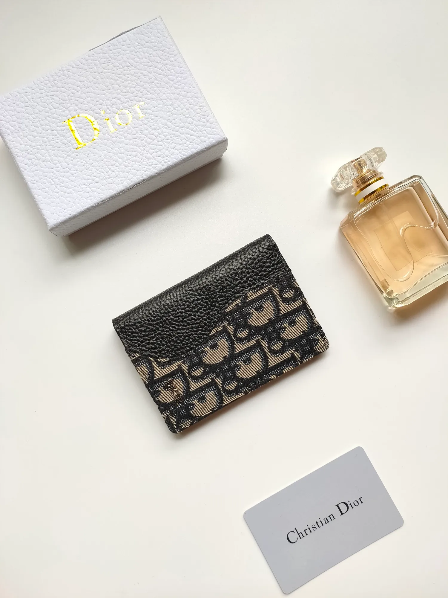￥100💋The newly launched bi-fold card holder for autumn 2023 is an elegant accessory that demonstrates Dior’s exquisite craftsmanship. Crafted from black inlaid grained calfskin, this card holder is detailed with beige and black Oblique print fabric details that accentuate the classic saddle silhouette. There are three card slots on each side and two compartments for storing bills and cash. Elegantly styled with a metal-clad brass Dior signature on the front, it fits easily into any pocket. Style number: CH169 Size: 8.2*11.2cm