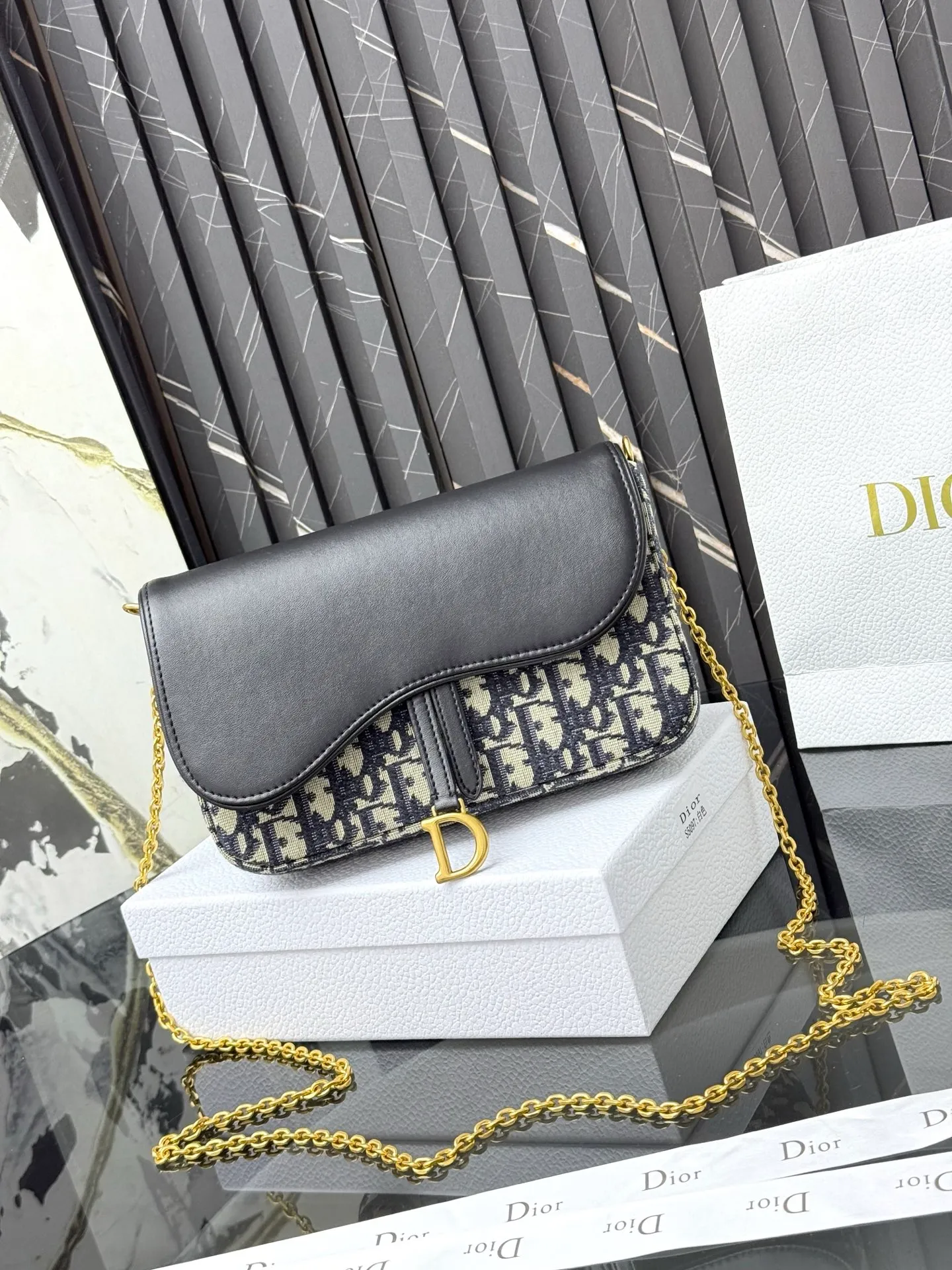 💰290💰 This saddle chain handbag has smooth and coordinated lines, making it a fashionable and practical item. Carefully crafted from blue Denim Dior Oblique jacquard fabric, the classic Dior pattern is reinterpreted with an irregular stonewash effect to highlight the fashionable style. It is paired with an asymmetric flap and a metal stirrup D-shaped pendant with antique gold finish. The spacious interior compartments can store a variety of daily essentials, and the chain makes it easy to carry on the shoulder or cross-body. Easily combines with other pieces from the saddle collection. Flap closure No.: S5907CTZQ_M928 Front stirrup D-shaped charm 1 compartment 6 card slots 1 slip pocket - No.: S5097 Dimensions: 21.5x12.5x3.7 cm (LxHxW) Can store 1 mobile phone, 1 card holder and lipstick Chain length: 118 cm Length from the top of the chain to the top of the bag: 57 cm