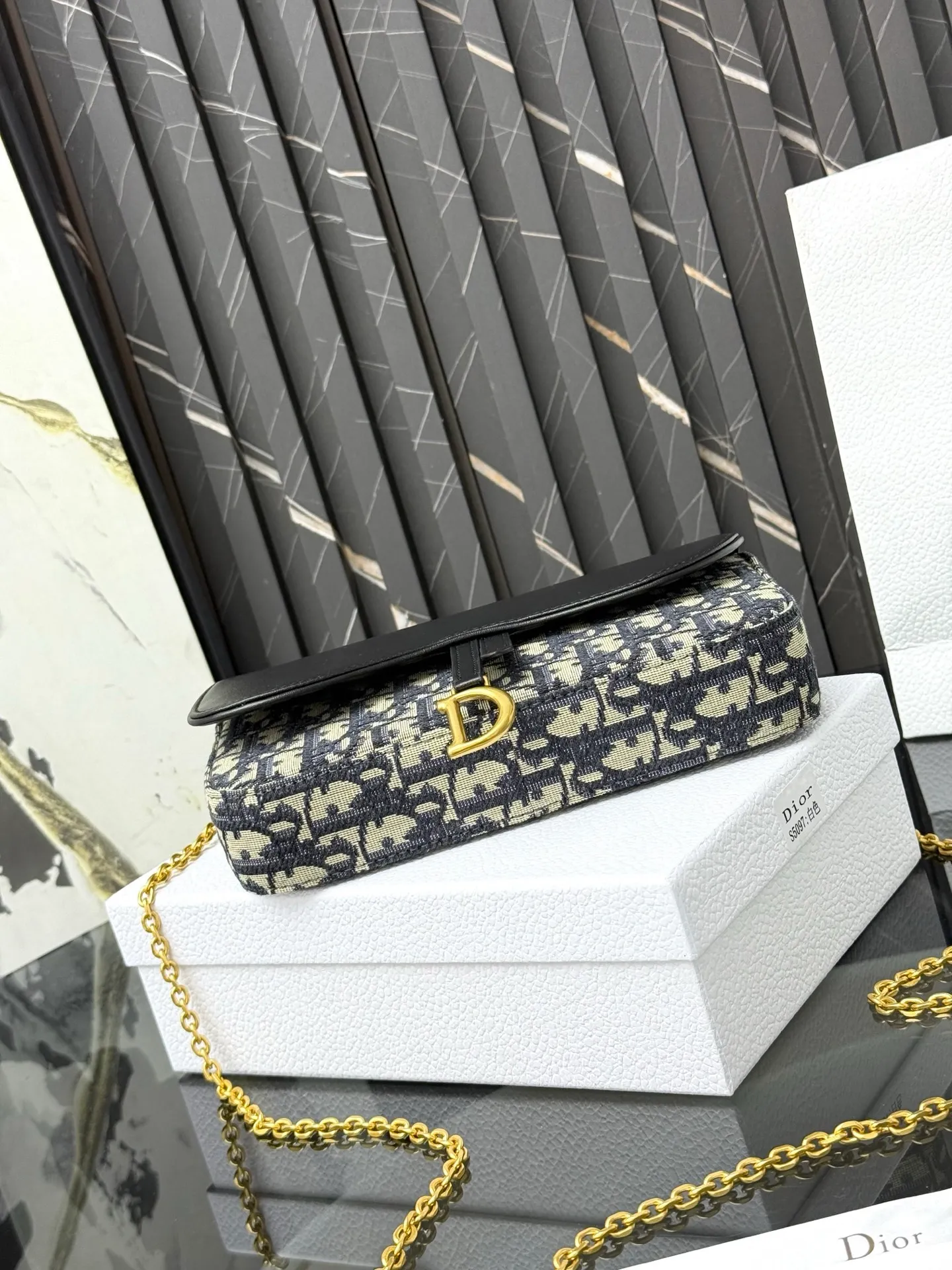 💰290💰 This saddle chain handbag has smooth and coordinated lines, making it a fashionable and practical item. Carefully crafted from blue Denim Dior Oblique jacquard fabric, the classic Dior pattern is reinterpreted with an irregular stonewash effect to highlight the fashionable style. It is paired with an asymmetric flap and a metal stirrup D-shaped pendant with antique gold finish. The spacious interior compartments can store a variety of daily essentials, and the chain makes it easy to carry on the shoulder or cross-body. Easily combines with other pieces from the saddle collection. Flap closure No.: S5907CTZQ_M928 Front stirrup D-shaped charm 1 compartment 6 card slots 1 slip pocket - No.: S5097 Dimensions: 21.5x12.5x3.7 cm (LxHxW) Can store 1 mobile phone, 1 card holder and lipstick Chain length: 118 cm Length from the top of the chain to the top of the bag: 57 cm
