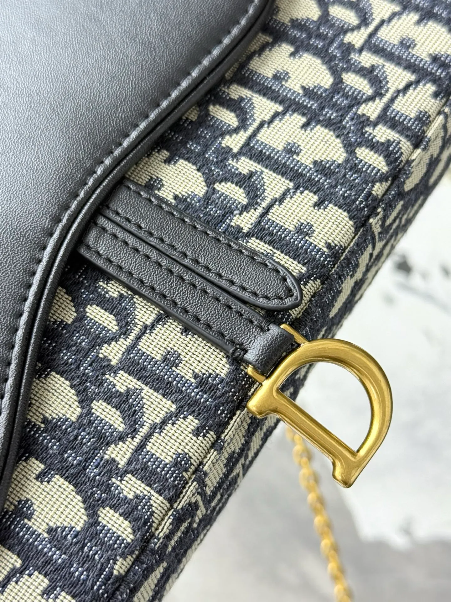 💰290💰 This saddle chain handbag has smooth and coordinated lines, making it a fashionable and practical item. Carefully crafted from blue Denim Dior Oblique jacquard fabric, the classic Dior pattern is reinterpreted with an irregular stonewash effect to highlight the fashionable style. It is paired with an asymmetric flap and a metal stirrup D-shaped pendant with antique gold finish. The spacious interior compartments can store a variety of daily essentials, and the chain makes it easy to carry on the shoulder or cross-body. Easily combines with other pieces from the saddle collection. Flap closure No.: S5907CTZQ_M928 Front stirrup D-shaped charm 1 compartment 6 card slots 1 slip pocket - No.: S5097 Dimensions: 21.5x12.5x3.7 cm (LxHxW) Can store 1 mobile phone, 1 card holder and lipstick Chain length: 118 cm Length from the top of the chain to the top of the bag: 57 cm