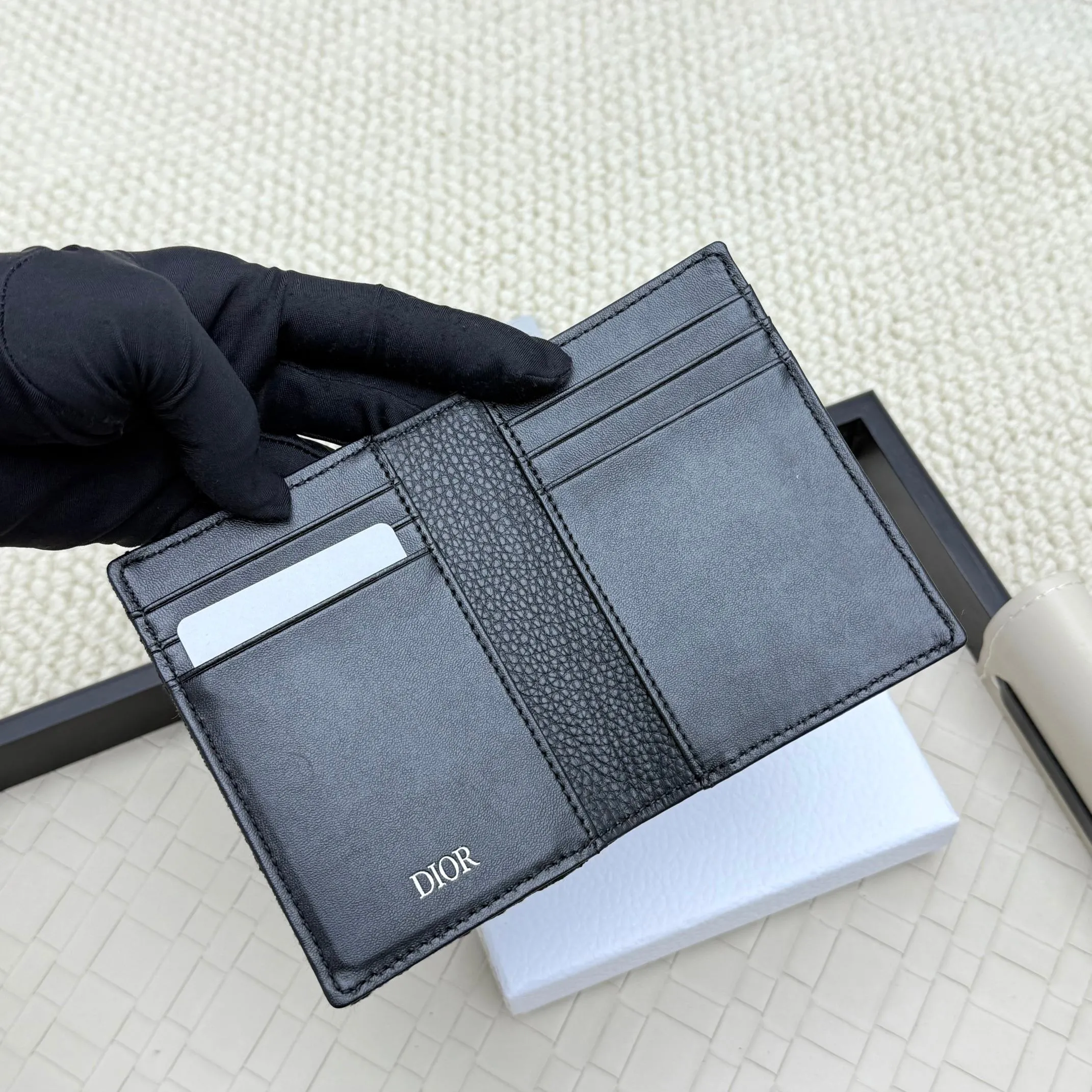 💰120💋Dior’s new bi-fold card holder is an elegant accessory that showcases Dior’s exquisite craftsmanship. Crafted from black inlaid grained calfskin, this card holder is detailed with beige and black Oblique print fabric details that accentuate the classic saddle silhouette. There are three card slots on each side and two compartments for storing bills and cash. Elegantly styled with a metal-clad brass Dior signature on the front, it fits easily into any pocket. Style number: H138 Size: 8.2*11.2cm
