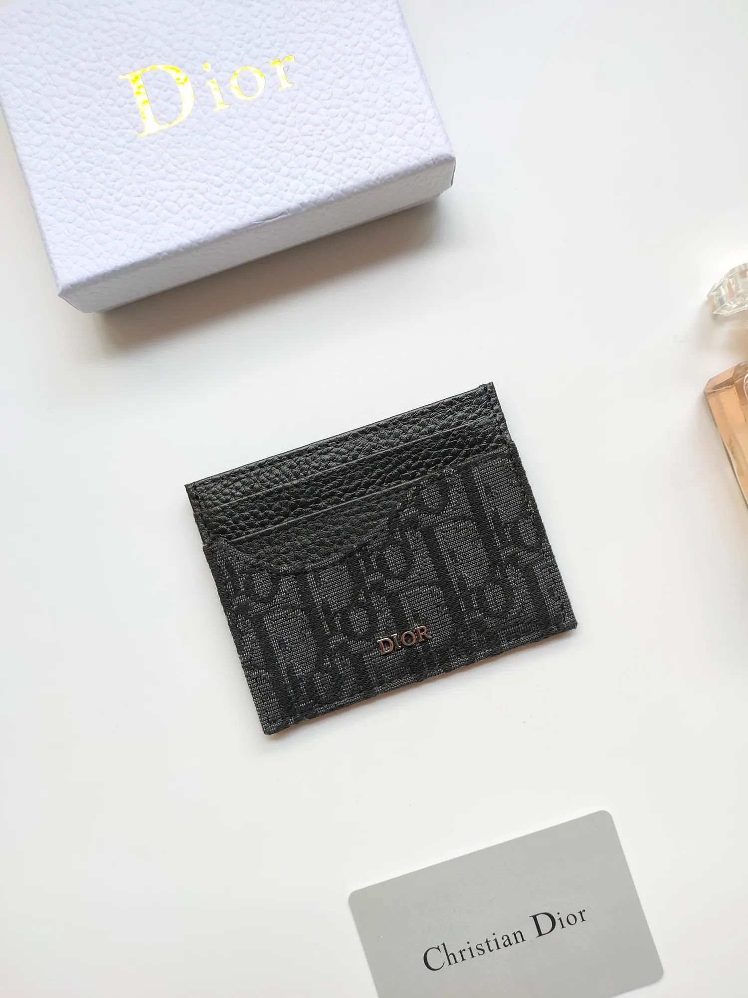 ￥90😍Dior’s new saddle card holder is an elegant accessory that showcases Dior’s exquisite craftsmanship. Style: CH164 Crafted from black grained calf leather with beige and black Oblique printed fabric details, it highlights the classic silhouette of the saddle series. It has three card slots on each side and one card slot on the top to store a variety of personal items. Elegantly styled with a metal-clad brass Dior signature on the front, it fits easily into any pocket. Size:10*8cm