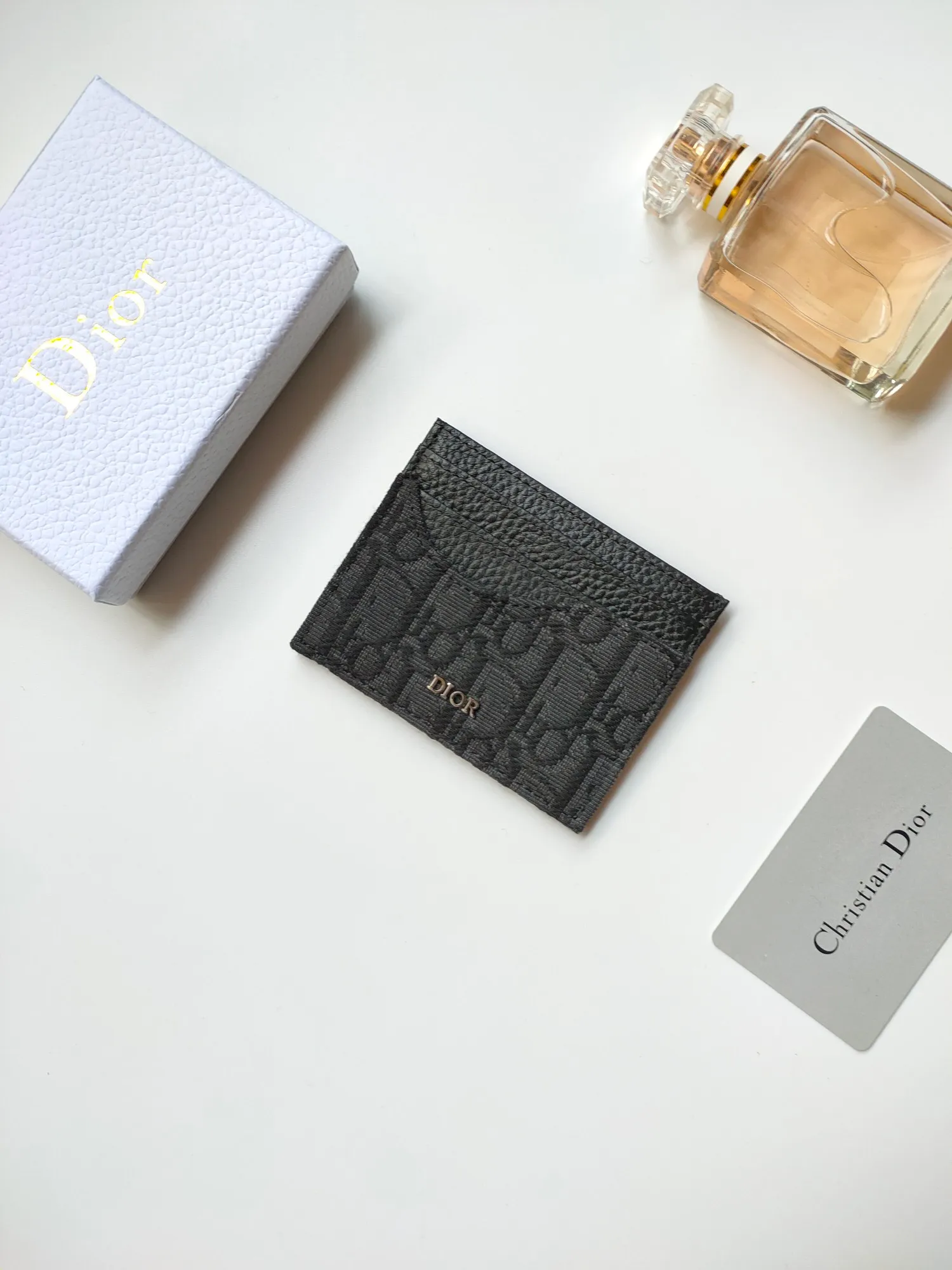 ￥90😍Dior’s new saddle card holder is an elegant accessory that showcases Dior’s exquisite craftsmanship. Style: CH164 Crafted from black grained calf leather with beige and black Oblique printed fabric details, it highlights the classic silhouette of the saddle series. It has three card slots on each side and one card slot on the top to store a variety of personal items. Elegantly styled with a metal-clad brass Dior signature on the front, it fits easily into any pocket. Size:10*8cm