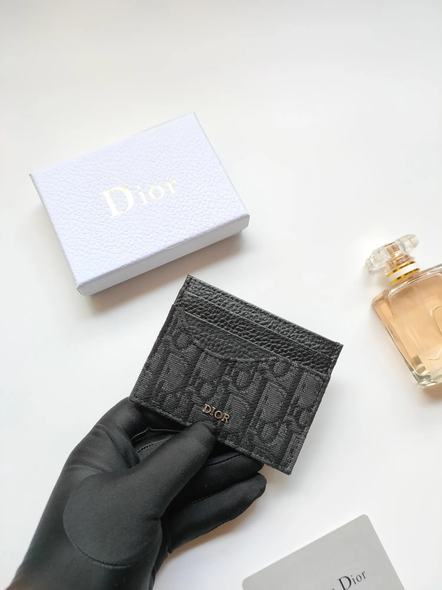 ￥90😍Dior’s new saddle card holder is an elegant accessory that showcases Dior’s exquisite craftsmanship. Style: CH164 Crafted from black grained calf leather with beige and black Oblique printed fabric details, it highlights the classic silhouette of the saddle series. It has three card slots on each side and one card slot on the top to store a variety of personal items. Elegantly styled with a metal-clad brass Dior signature on the front, it fits easily into any pocket. Size:10*8cm