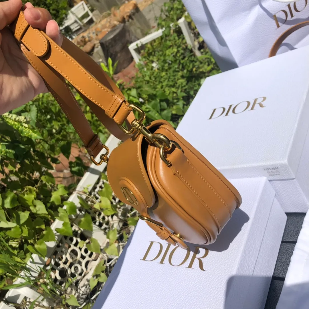 Top upgraded version💰1700 Small size: 18×14×5cm Dior’s new products are available through overseas channels! The Dior Bobby bag is designed as a shoulder bag, highlighting its elegant silhouette and harmonious proportions. This small bag is crafted from camel glossy calfskin and accented with antiqued gold hardware for added style. The interior is designed with suede leather, which is soft and rich in texture. With a detachable and adjustable shoulder strap embellished with a military-style buckle, it can be worn on the shoulder, cross-body or handheld.