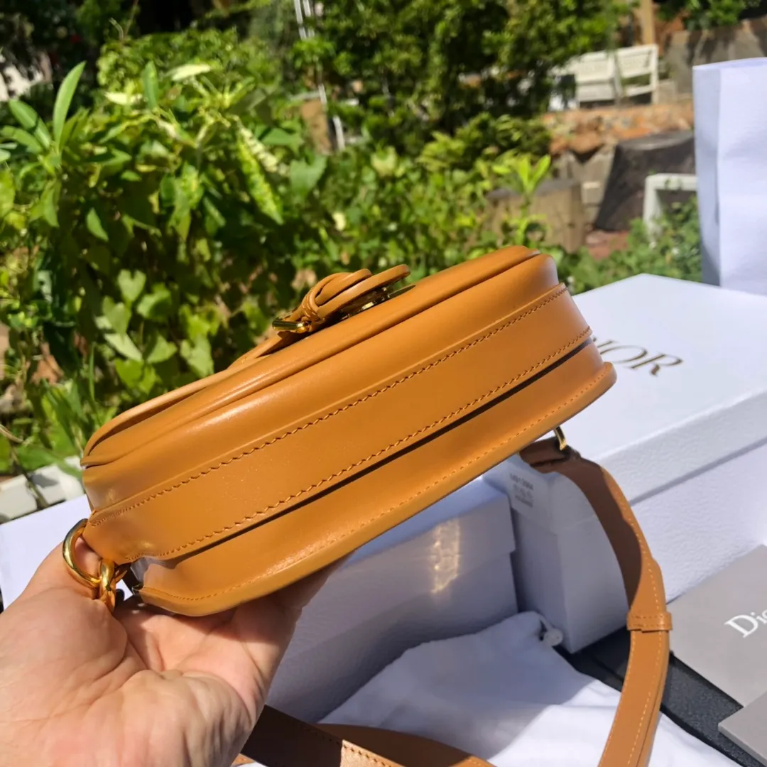 Top upgraded version💰1700 Small size: 18×14×5cm Dior’s new products are available through overseas channels! The Dior Bobby bag is designed as a shoulder bag, highlighting its elegant silhouette and harmonious proportions. This small bag is crafted from camel glossy calfskin and accented with antiqued gold hardware for added style. The interior is designed with suede leather, which is soft and rich in texture. With a detachable and adjustable shoulder strap embellished with a military-style buckle, it can be worn on the shoulder, cross-body or handheld.