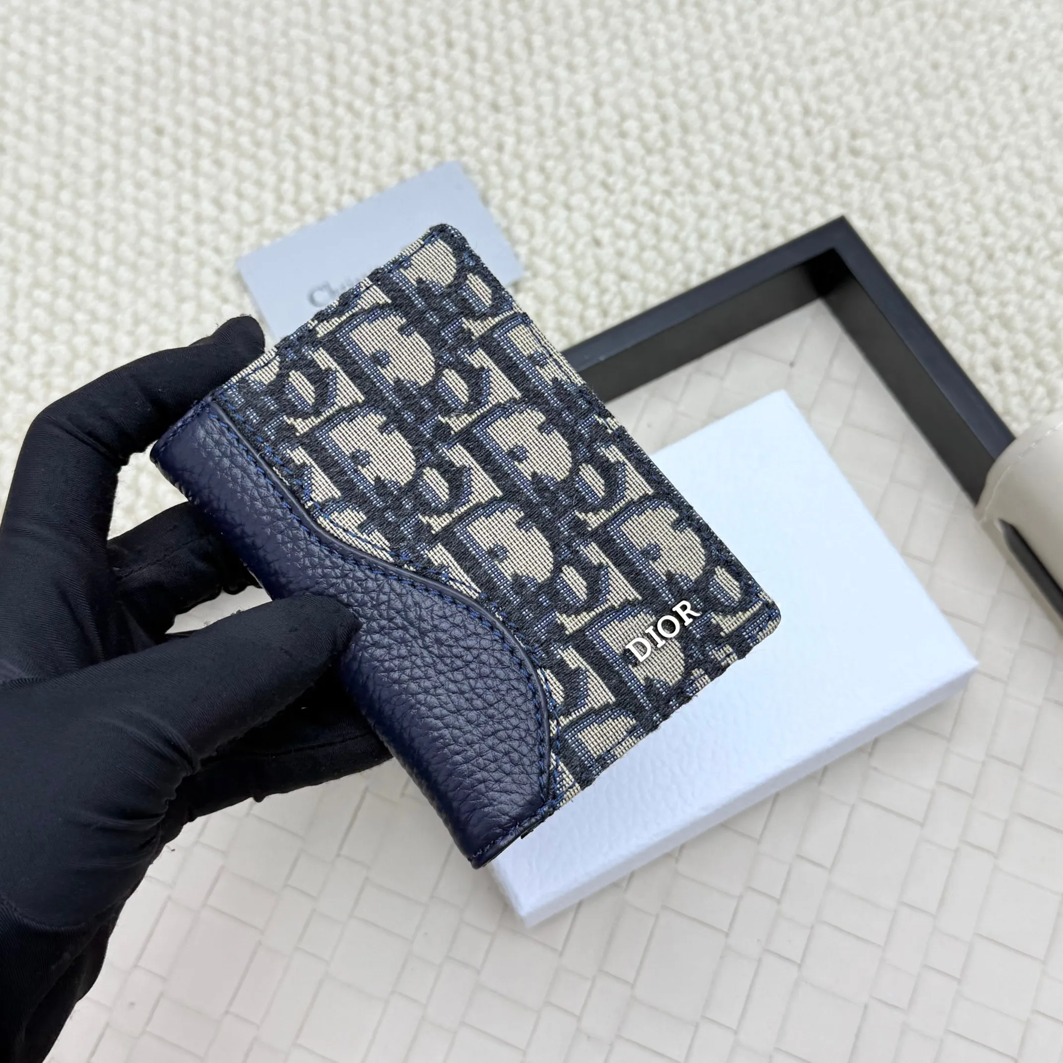 💰120💋Dior’s new bi-fold card holder is an elegant accessory that showcases Dior’s exquisite craftsmanship. Crafted from black inlaid grained calfskin, this card holder is detailed with beige and black Oblique print fabric details that accentuate the classic saddle silhouette. There are three card slots on each side and two compartments for storing bills and cash. Elegantly styled with a metal-clad brass Dior signature on the front, it fits easily into any pocket. Style number: H138 Size: 8.2*11.2cm