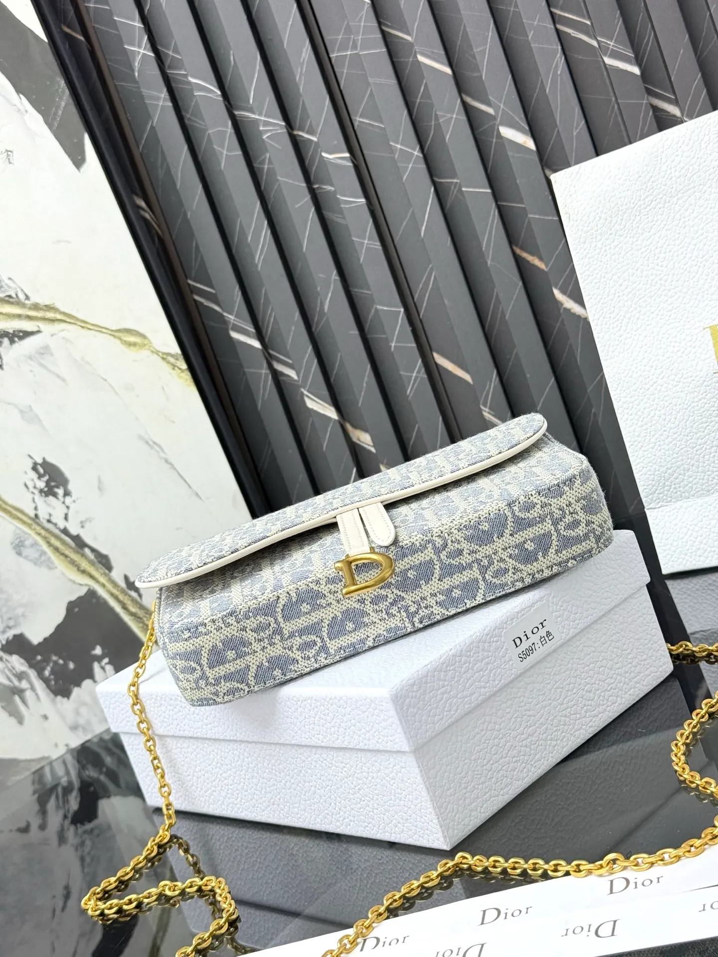 💰290💰 This saddle chain handbag has smooth and coordinated lines, making it a fashionable and practical item. Carefully crafted from blue Denim Dior Oblique jacquard fabric, the classic Dior pattern is reinterpreted with an irregular stonewash effect to highlight the fashionable style. It is paired with an asymmetric flap and a metal stirrup D-shaped pendant with antique gold finish. The spacious interior compartments can store a variety of daily essentials, and the chain makes it easy to carry on the shoulder or cross-body. Easily combines with other pieces from the saddle collection. Flap closure No.: S5907CTZQ_M928 Front stirrup D-shaped charm 1 compartment 6 card slots 1 slip pocket - No.: S5097 Dimensions: 21.5x12.5x3.7 cm (LxHxW) Can store 1 mobile phone, 1 card holder and lipstick Chain length: 118 cm Length from the top of the chain to the top of the bag: 57 cm