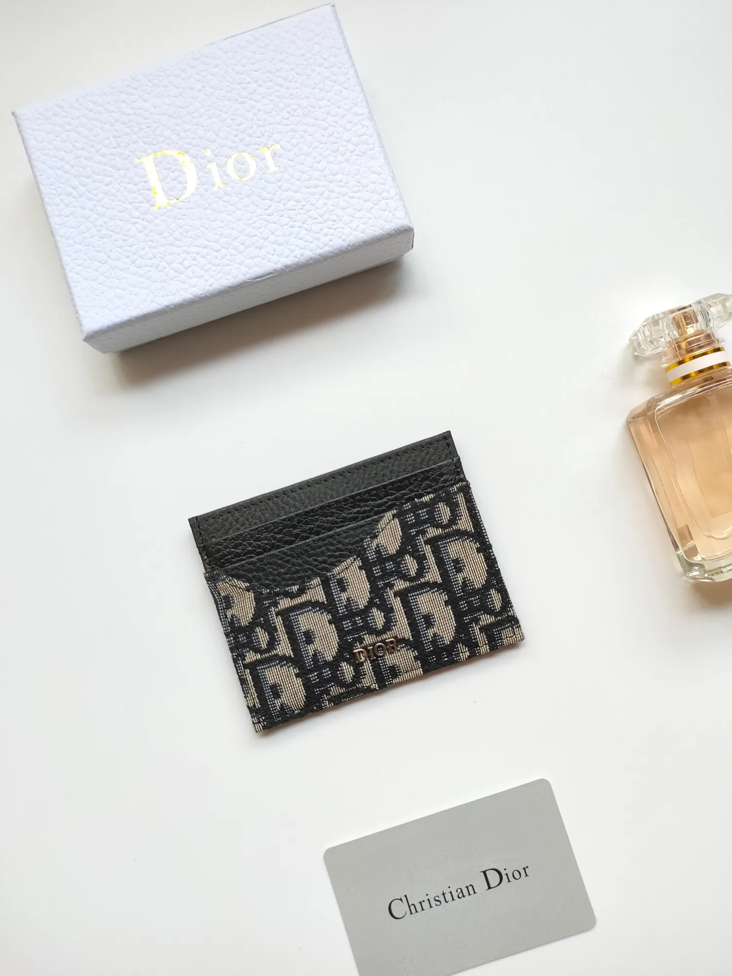 ￥90😍Dior’s new saddle card holder is an elegant accessory that showcases Dior’s exquisite craftsmanship. Style: CH164 Crafted from black grained calf leather with beige and black Oblique printed fabric details, it highlights the classic silhouette of the saddle series. It has three card slots on each side and one card slot on the top to store a variety of personal items. Elegantly styled with a metal-clad brass Dior signature on the front, it fits easily into any pocket. Size:10*8cm