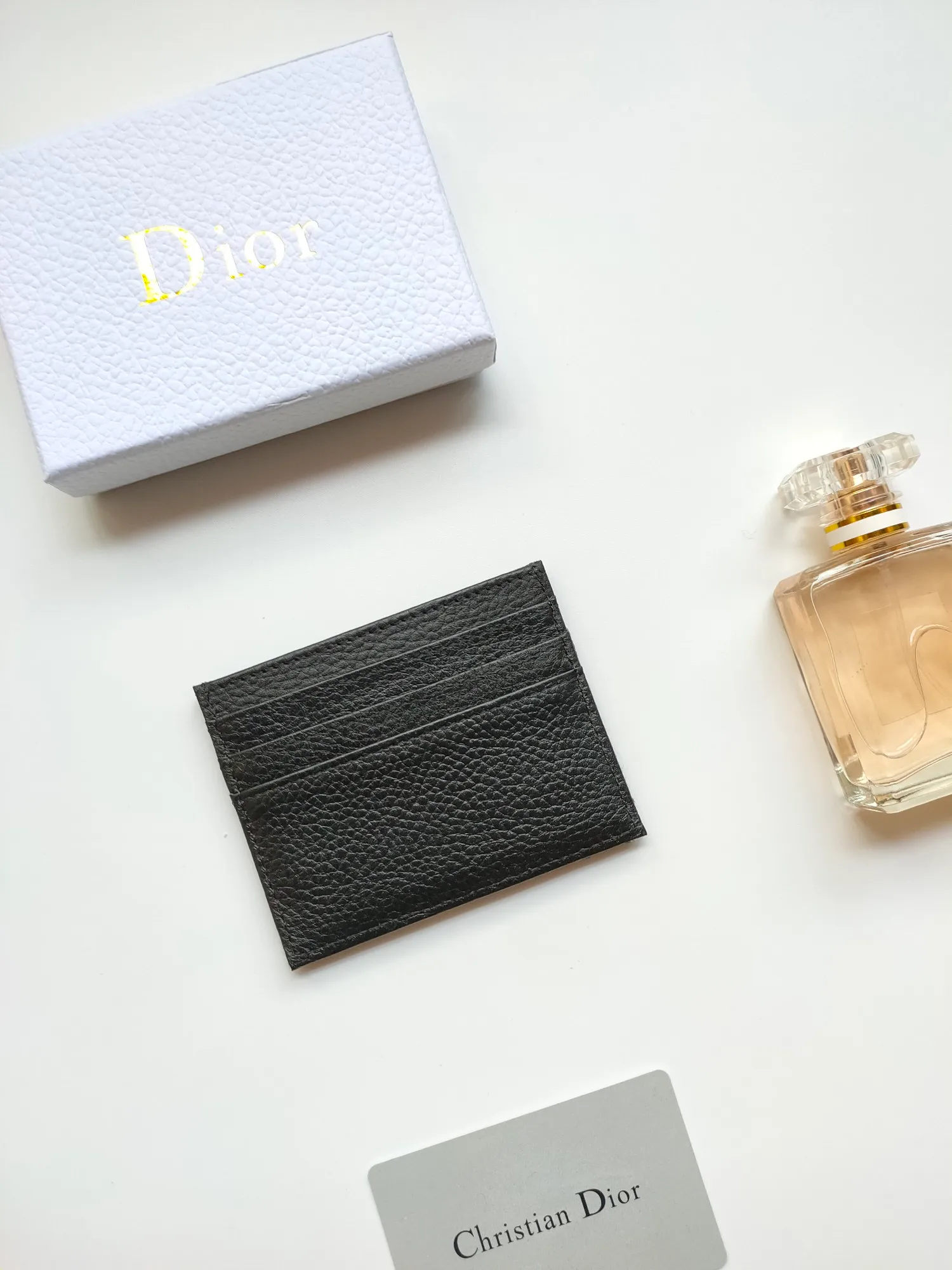 ￥90😍Dior’s new saddle card holder is an elegant accessory that showcases Dior’s exquisite craftsmanship. Style: CH164 Crafted from black grained calf leather with beige and black Oblique printed fabric details, it highlights the classic silhouette of the saddle series. It has three card slots on each side and one card slot on the top to store a variety of personal items. Elegantly styled with a metal-clad brass Dior signature on the front, it fits easily into any pocket. Size:10*8cm