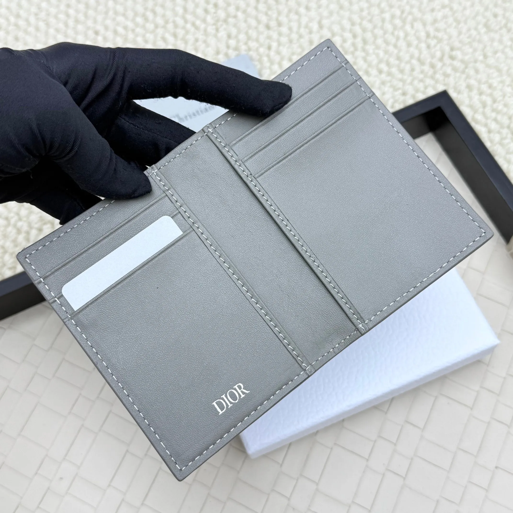 💰120💋Dior’s new bi-fold card holder is an elegant accessory that showcases Dior’s exquisite craftsmanship. Crafted from black inlaid grained calfskin, this card holder is detailed with beige and black Oblique print fabric details that accentuate the classic saddle silhouette. There are three card slots on each side and two compartments for storing bills and cash. Elegantly styled with a metal-clad brass Dior signature on the front, it fits easily into any pocket. Style number: H138 Size: 8.2*11.2cm