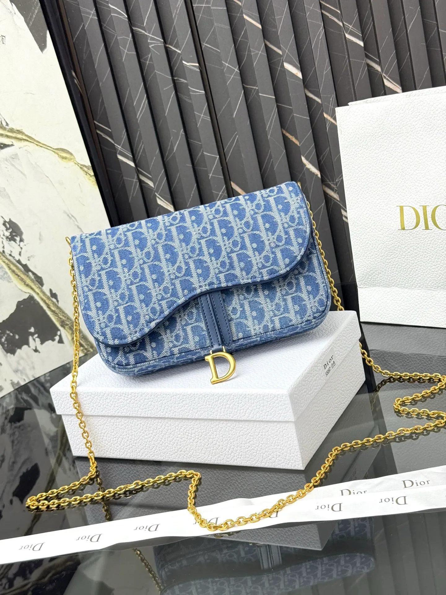 💰290💰 This saddle chain handbag has smooth and coordinated lines, making it a fashionable and practical item. Carefully crafted from blue Denim Dior Oblique jacquard fabric, the classic Dior pattern is reinterpreted with an irregular stonewash effect to highlight the fashionable style. It is paired with an asymmetric flap and a metal stirrup D-shaped pendant with antique gold finish. The spacious interior compartments can store a variety of daily essentials, and the chain makes it easy to carry on the shoulder or cross-body. Easily combines with other pieces from the saddle collection. Flap closure No.: S5907CTZQ_M928 Front stirrup D-shaped charm 1 compartment 6 card slots 1 slip pocket - No.: S5097 Dimensions: 21.5x12.5x3.7 cm (LxHxW) Can store 1 mobile phone, 1 card holder and lipstick Chain length: 118 cm Length from the top of the chain to the top of the bag: 57 cm