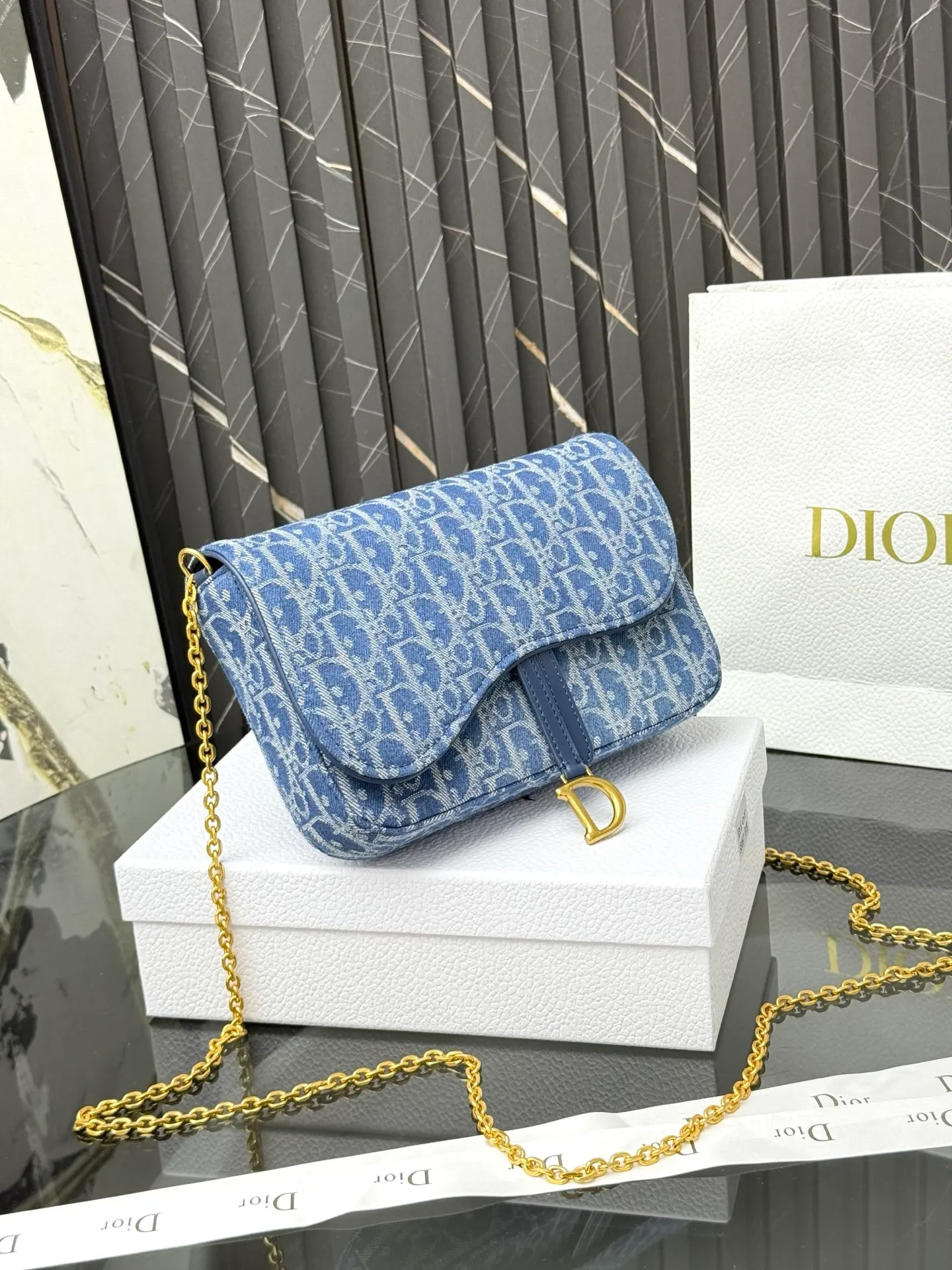 💰290💰 This saddle chain handbag has smooth and coordinated lines, making it a fashionable and practical item. Carefully crafted from blue Denim Dior Oblique jacquard fabric, the classic Dior pattern is reinterpreted with an irregular stonewash effect to highlight the fashionable style. It is paired with an asymmetric flap and a metal stirrup D-shaped pendant with antique gold finish. The spacious interior compartments can store a variety of daily essentials, and the chain makes it easy to carry on the shoulder or cross-body. Easily combines with other pieces from the saddle collection. Flap closure No.: S5907CTZQ_M928 Front stirrup D-shaped charm 1 compartment 6 card slots 1 slip pocket - No.: S5097 Dimensions: 21.5x12.5x3.7 cm (LxHxW) Can store 1 mobile phone, 1 card holder and lipstick Chain length: 118 cm Length from the top of the chain to the top of the bag: 57 cm