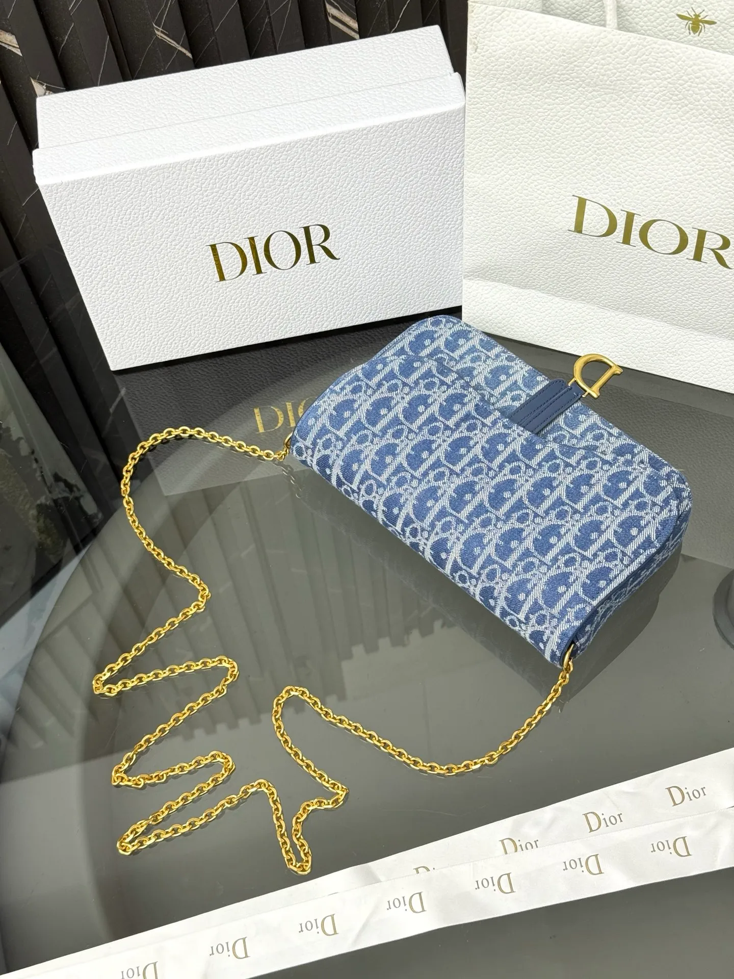 💰290💰 This saddle chain handbag has smooth and coordinated lines, making it a fashionable and practical item. Carefully crafted from blue Denim Dior Oblique jacquard fabric, the classic Dior pattern is reinterpreted with an irregular stonewash effect to highlight the fashionable style. It is paired with an asymmetric flap and a metal stirrup D-shaped pendant with antique gold finish. The spacious interior compartments can store a variety of daily essentials, and the chain makes it easy to carry on the shoulder or cross-body. Easily combines with other pieces from the saddle collection. Flap closure No.: S5907CTZQ_M928 Front stirrup D-shaped charm 1 compartment 6 card slots 1 slip pocket - No.: S5097 Dimensions: 21.5x12.5x3.7 cm (LxHxW) Can store 1 mobile phone, 1 card holder and lipstick Chain length: 118 cm Length from the top of the chain to the top of the bag: 57 cm
