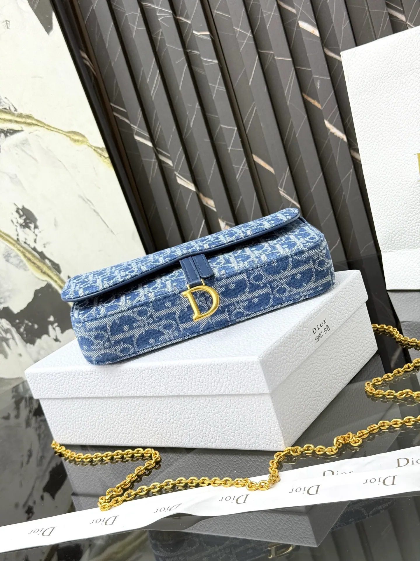 💰290💰 This saddle chain handbag has smooth and coordinated lines, making it a fashionable and practical item. Carefully crafted from blue Denim Dior Oblique jacquard fabric, the classic Dior pattern is reinterpreted with an irregular stonewash effect to highlight the fashionable style. It is paired with an asymmetric flap and a metal stirrup D-shaped pendant with antique gold finish. The spacious interior compartments can store a variety of daily essentials, and the chain makes it easy to carry on the shoulder or cross-body. Easily combines with other pieces from the saddle collection. Flap closure No.: S5907CTZQ_M928 Front stirrup D-shaped charm 1 compartment 6 card slots 1 slip pocket - No.: S5097 Dimensions: 21.5x12.5x3.7 cm (LxHxW) Can store 1 mobile phone, 1 card holder and lipstick Chain length: 118 cm Length from the top of the chain to the top of the bag: 57 cm