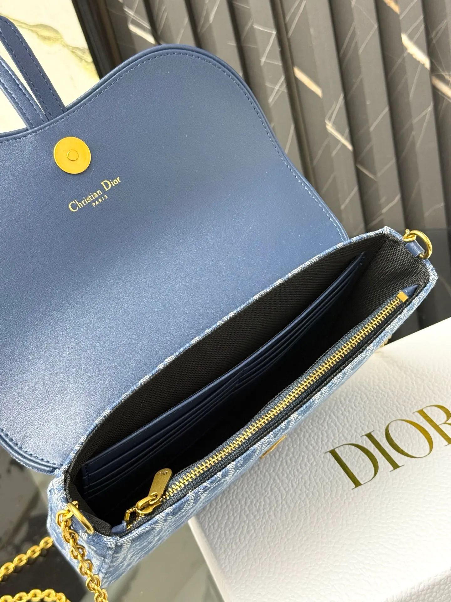 💰290💰 This saddle chain handbag has smooth and coordinated lines, making it a fashionable and practical item. Carefully crafted from blue Denim Dior Oblique jacquard fabric, the classic Dior pattern is reinterpreted with an irregular stonewash effect to highlight the fashionable style. It is paired with an asymmetric flap and a metal stirrup D-shaped pendant with antique gold finish. The spacious interior compartments can store a variety of daily essentials, and the chain makes it easy to carry on the shoulder or cross-body. Easily combines with other pieces from the saddle collection. Flap closure No.: S5907CTZQ_M928 Front stirrup D-shaped charm 1 compartment 6 card slots 1 slip pocket - No.: S5097 Dimensions: 21.5x12.5x3.7 cm (LxHxW) Can store 1 mobile phone, 1 card holder and lipstick Chain length: 118 cm Length from the top of the chain to the top of the bag: 57 cm